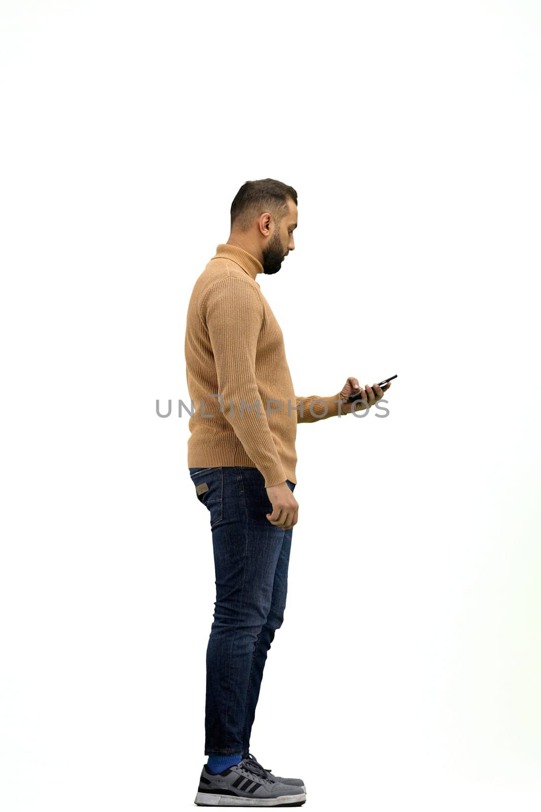 A man, full-length, on a white background, talking on the phone.