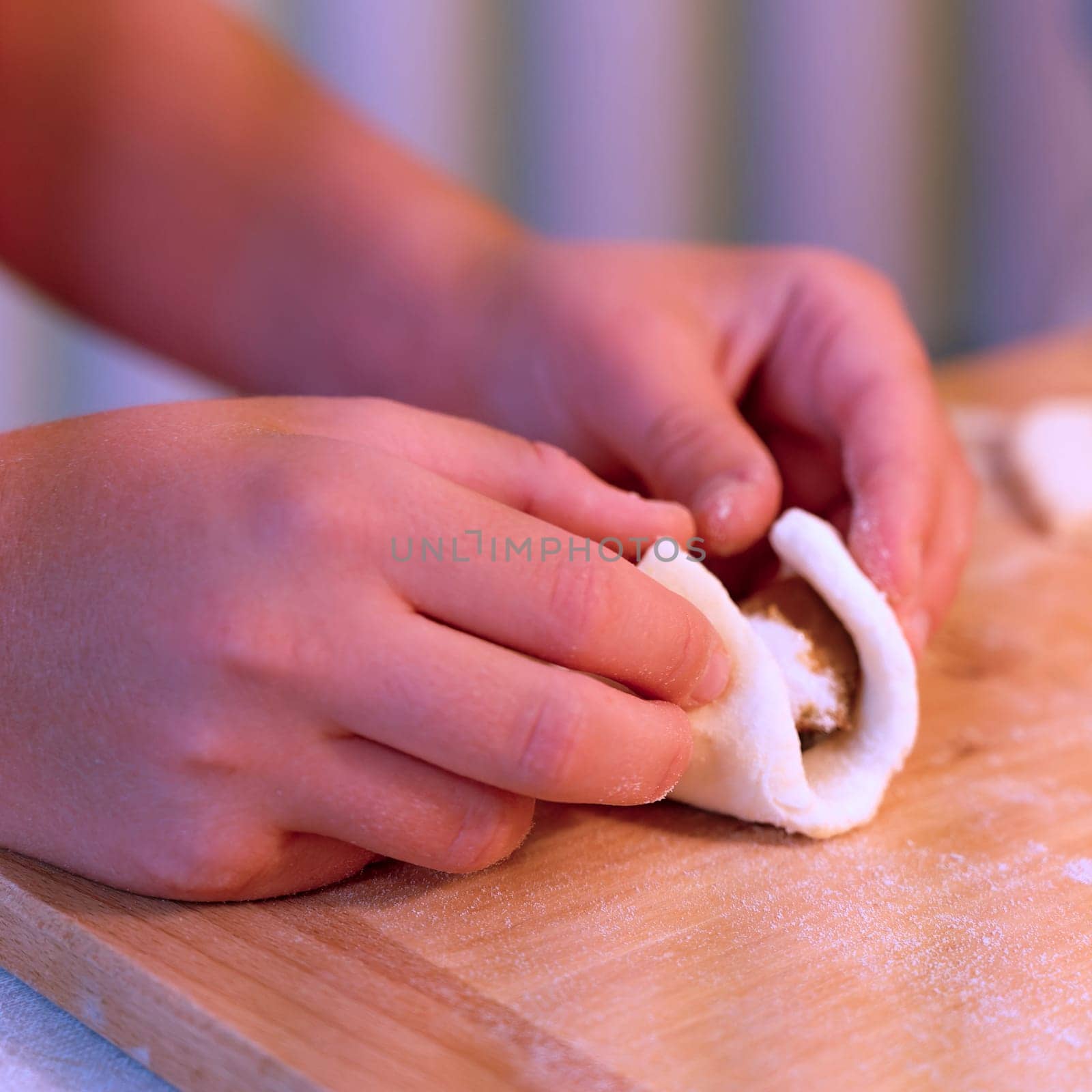 Preparation of homemade fruit dumplings with plums. Czech specialty of sweet good food. Dough on kitchen wooden table with hands.