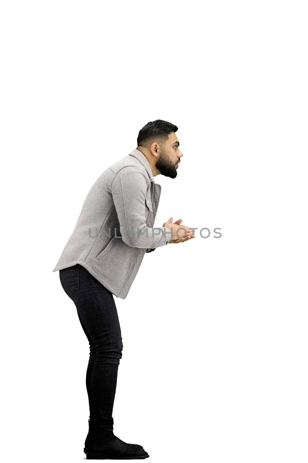 A man, full-length, on a white background, rubs his hands.