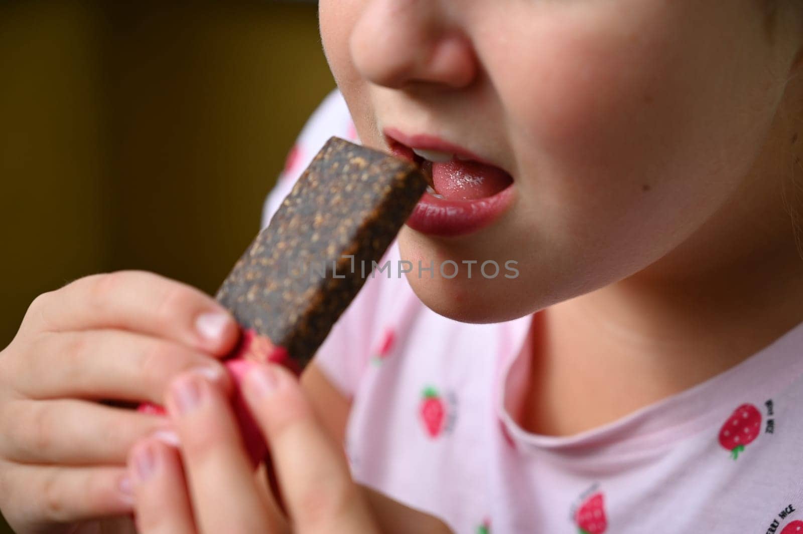 Young girl - child eating candy and sweets. Detail of face and mouth. Concept for healthy lifestyle - healthy - unhealthy sweet food and sugar.