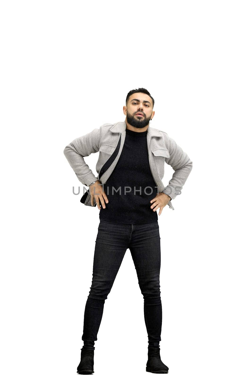 Man, full-length, on a white background, hands on hips.