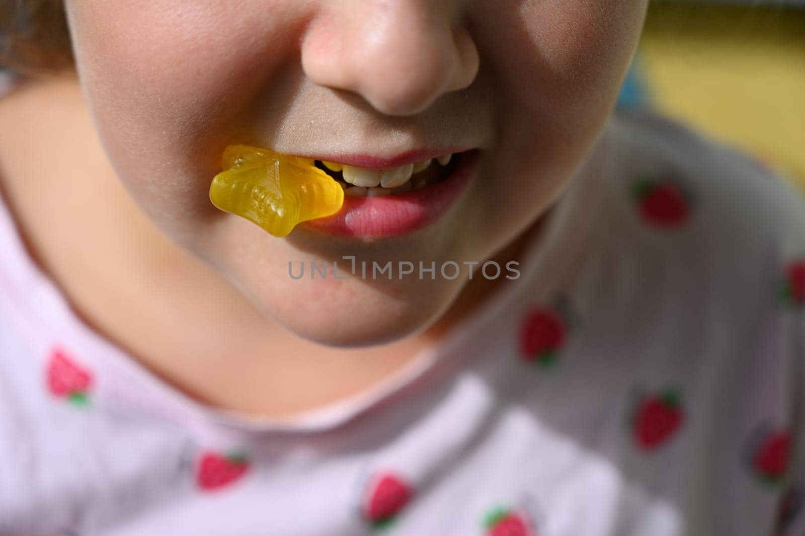 Young girl - child eating candy and sweets. Detail of face and mouth. Concept for healthy lifestyle - healthy - unhealthy sweet food and sugar. by Montypeter