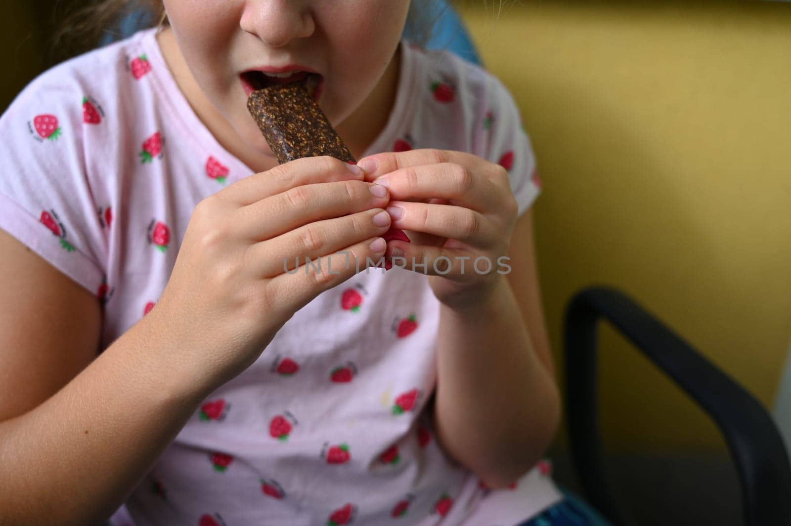 Young girl - child eating candy and sweets. Detail of face and mouth. Concept for healthy lifestyle - healthy - unhealthy sweet food and sugar. by Montypeter