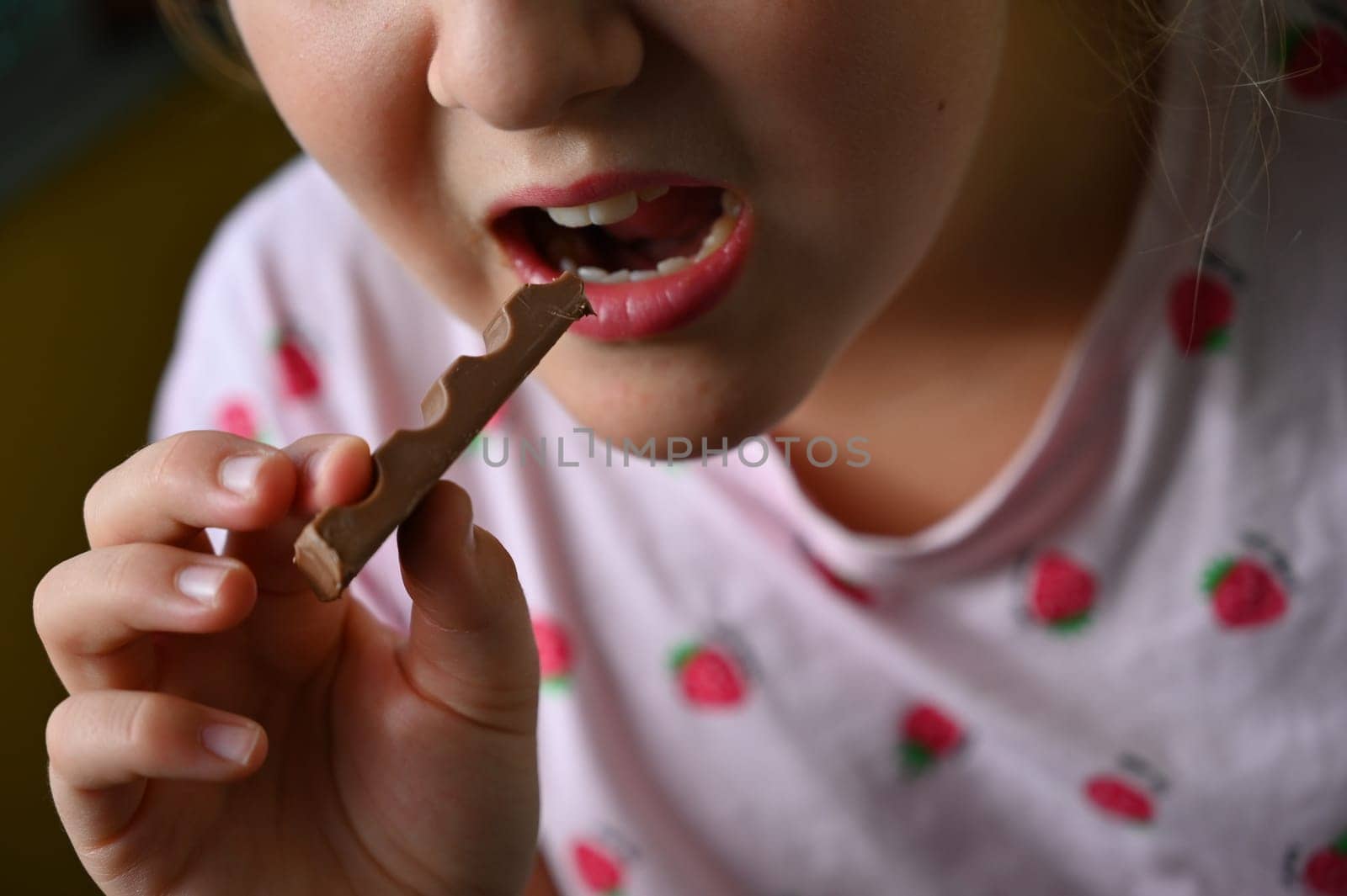 Young girl - child eating candy and sweets. Detail of face and mouth. Concept for healthy lifestyle - healthy - unhealthy sweet food and sugar. by Montypeter