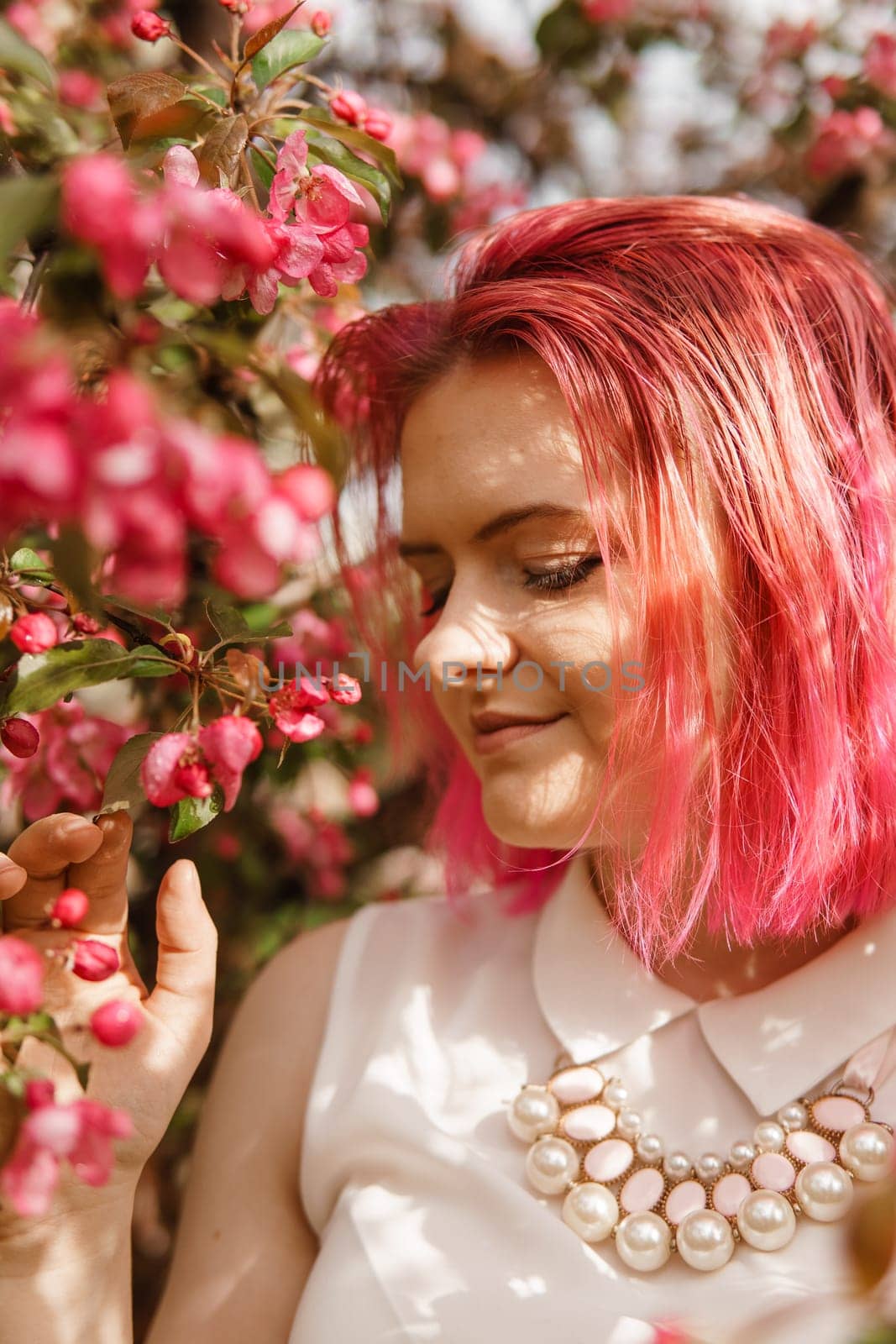 Young girl with pink hair in an Apple orchard. Beautiful young girl in a blooming garden of pink Apple trees. by Annu1tochka