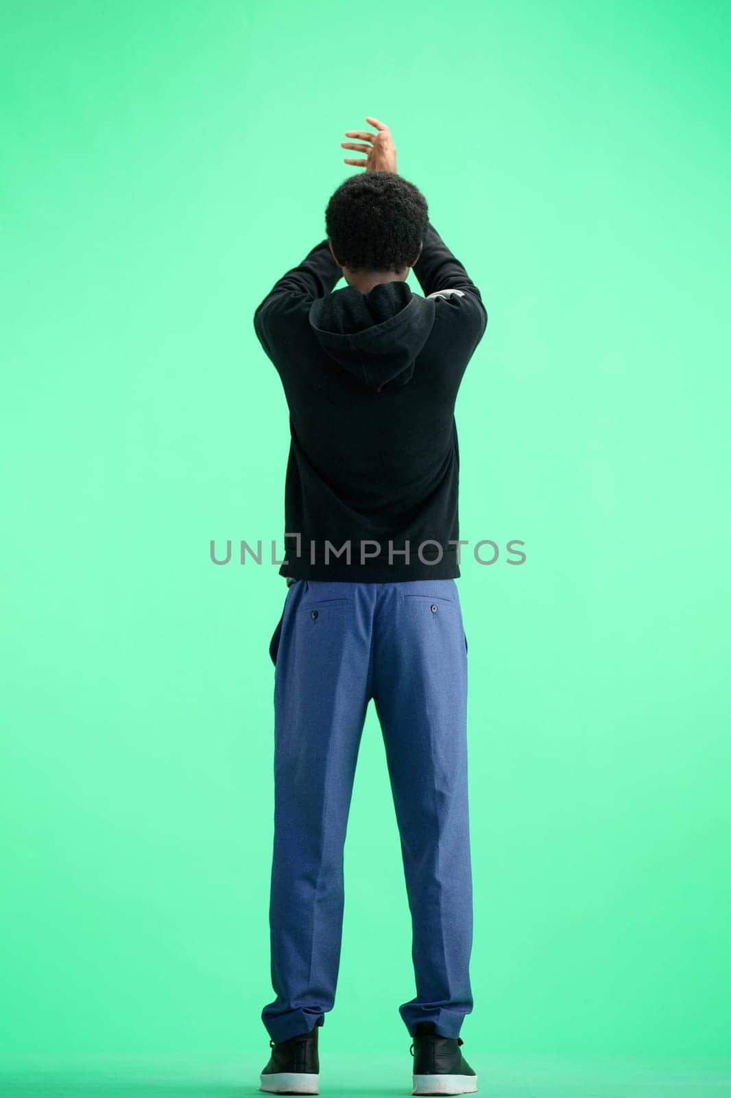 A man, full-length, on a green background, claps by Prosto