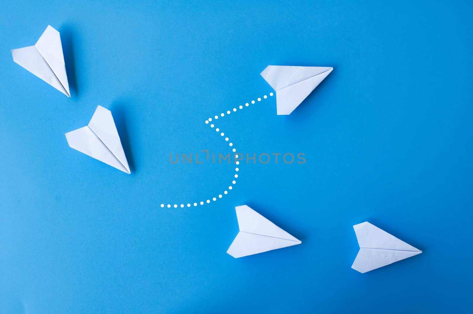 Top view of white paper airplanes origami with one flying at different direction