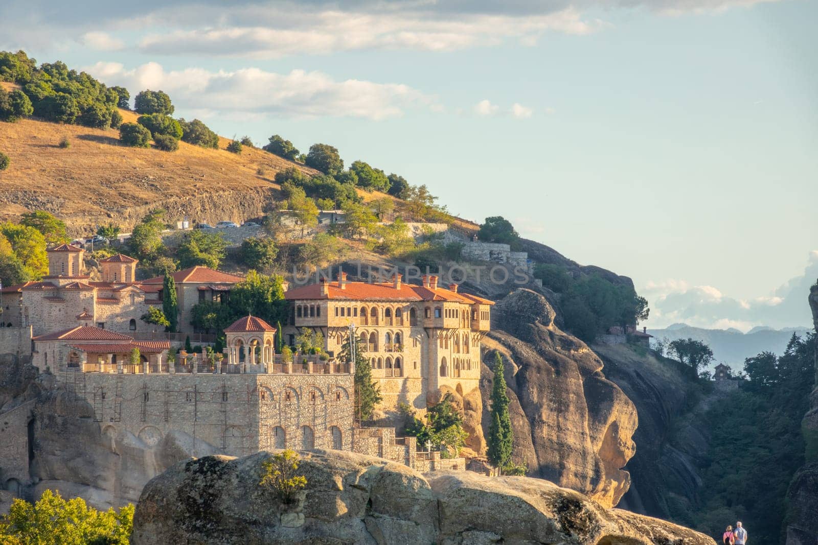 Greece. Summer day in Kalambaka. The sun is going down. Rock monastery with red roofs