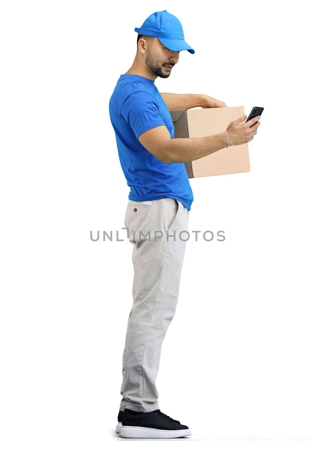 The deliveryman, in full height, on a white background, with a box and a phone.