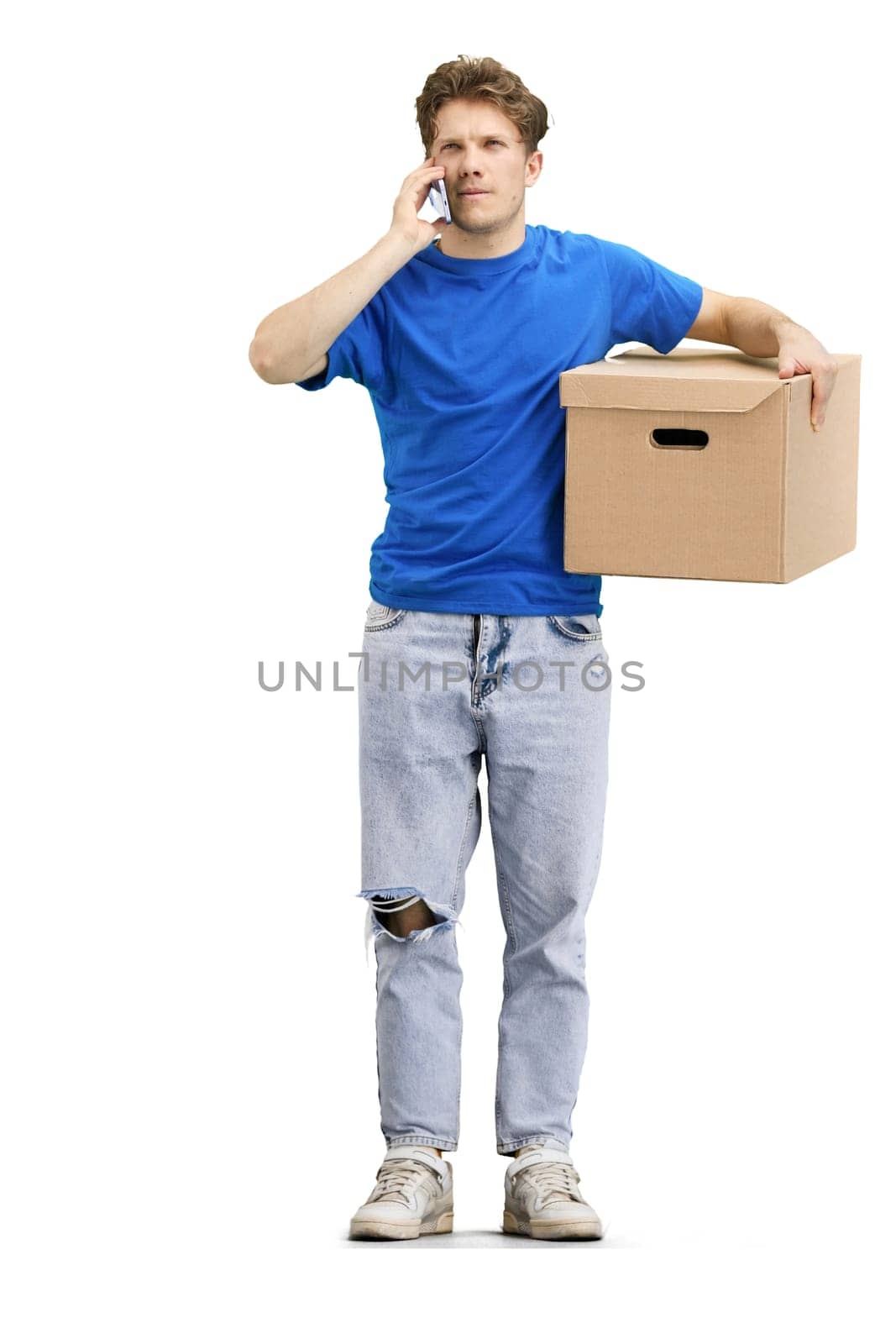 The deliveryman, in full height, on a white background, with a box, talking on the phone.