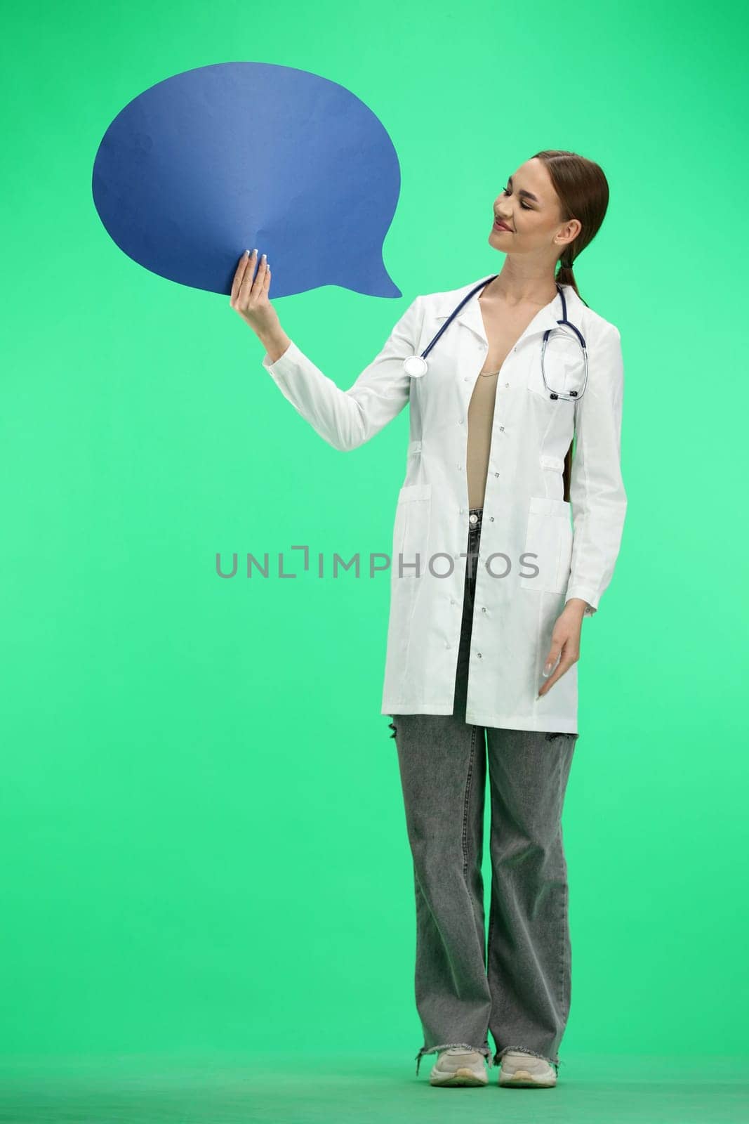 A full-length female doctor, on a green background, shows a blue comment sign.