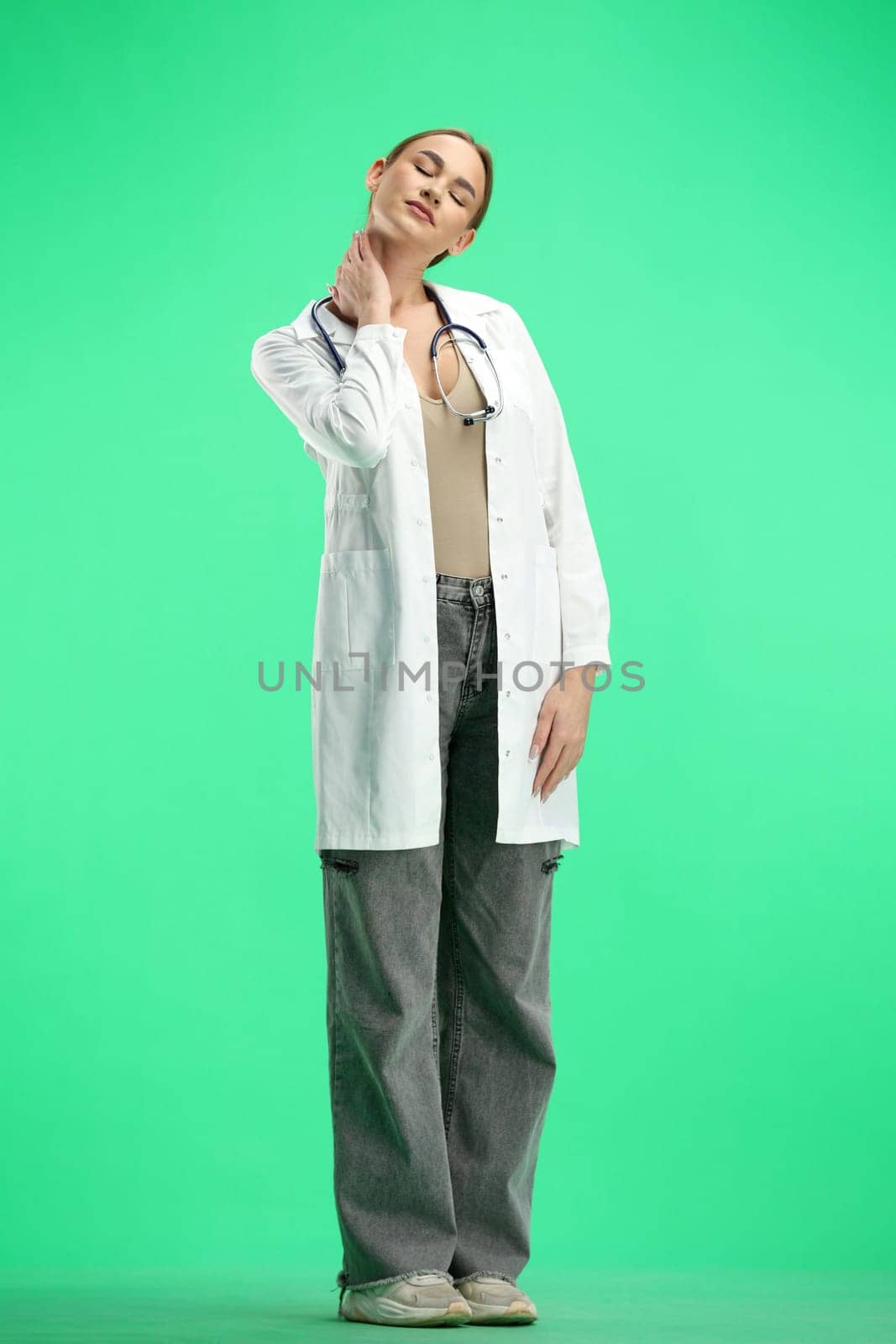 Female doctor, close-up, on a green background, tired.