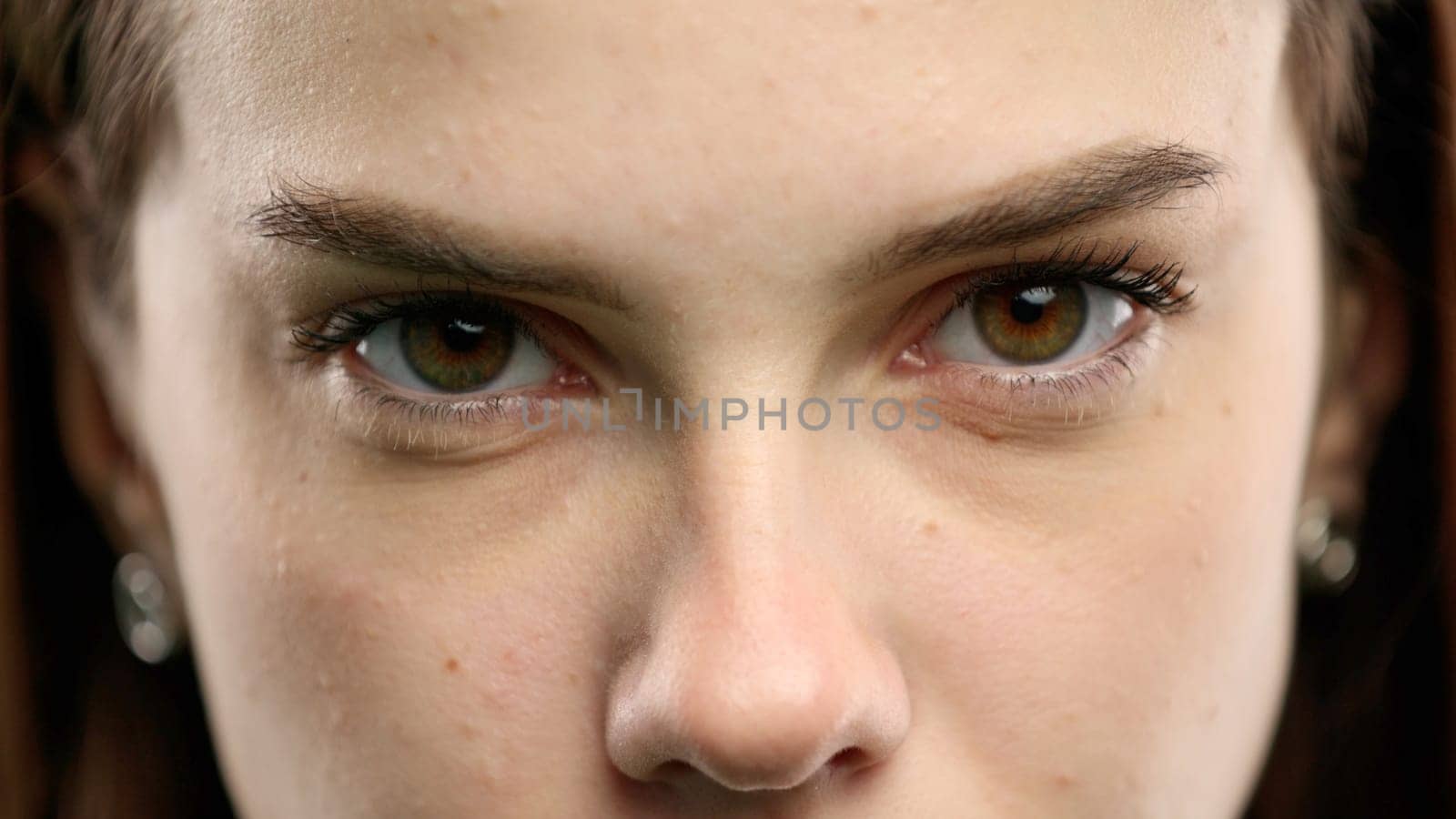 Woman's face, close-up, on a green background.