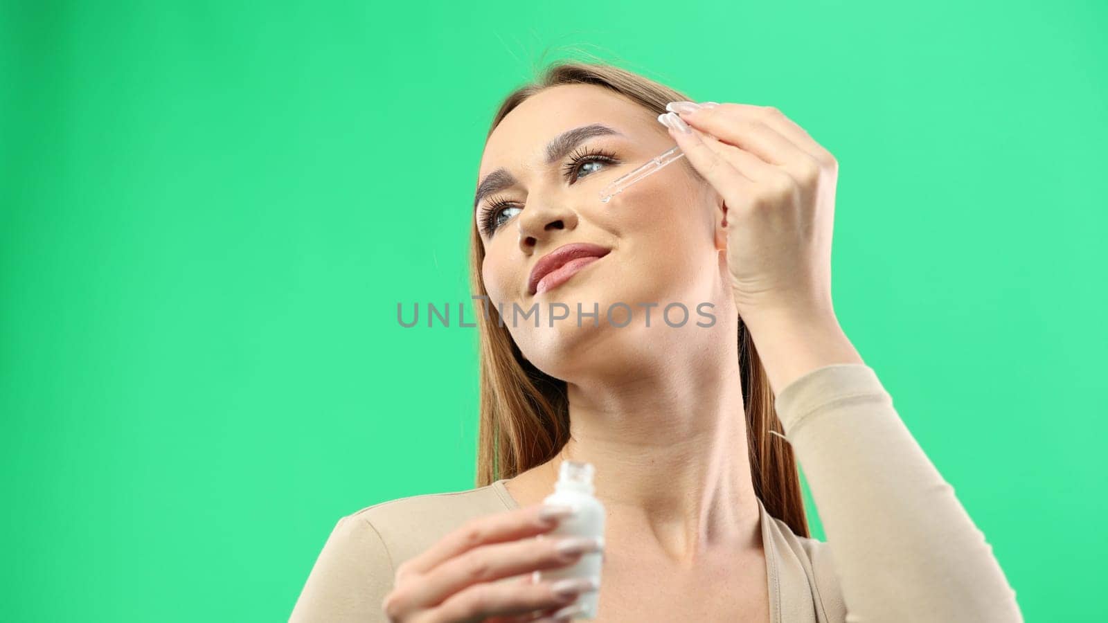 Woman's face, close-up, on a green background.