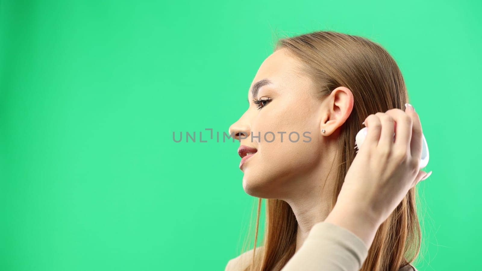 Woman's face, close-up, on a green background.