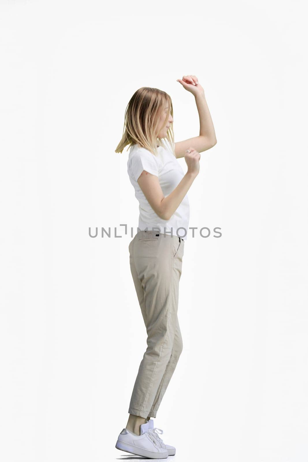 A woman, full-length, on a white background, dancing.