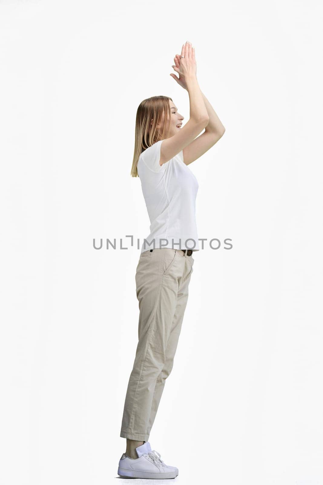A woman, full-length, on a white background, claps.