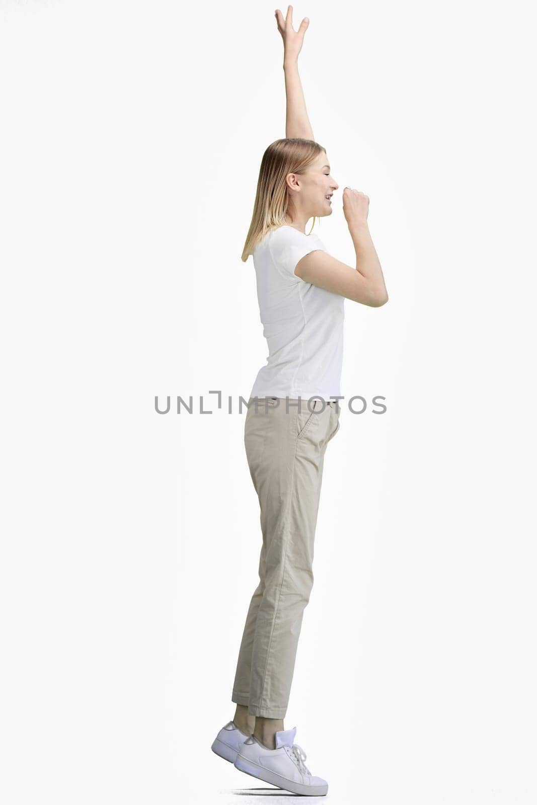 A woman, full-length, on a white background, rejoices.