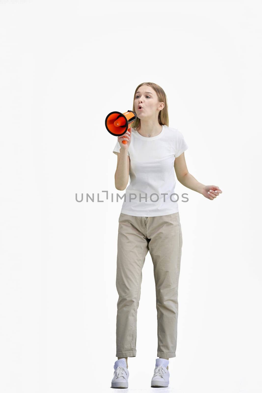 A woman, full-length, on a white background, with a megaphone.