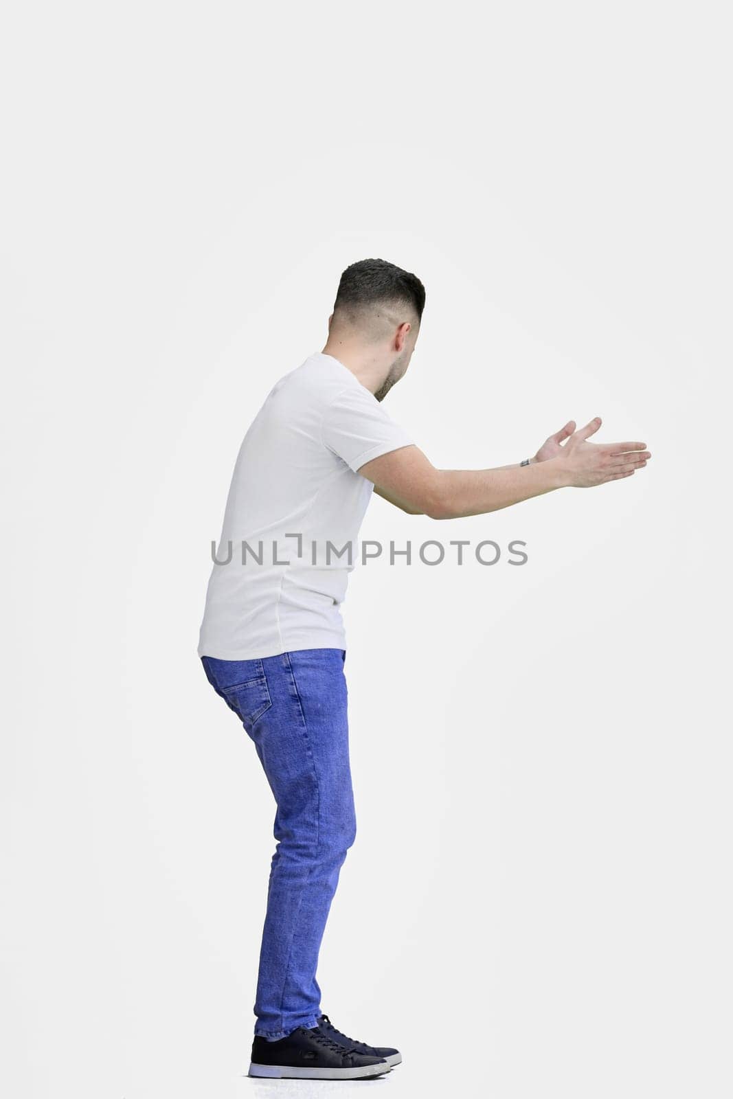 A man, full-length, on a white background, spreads his arms.