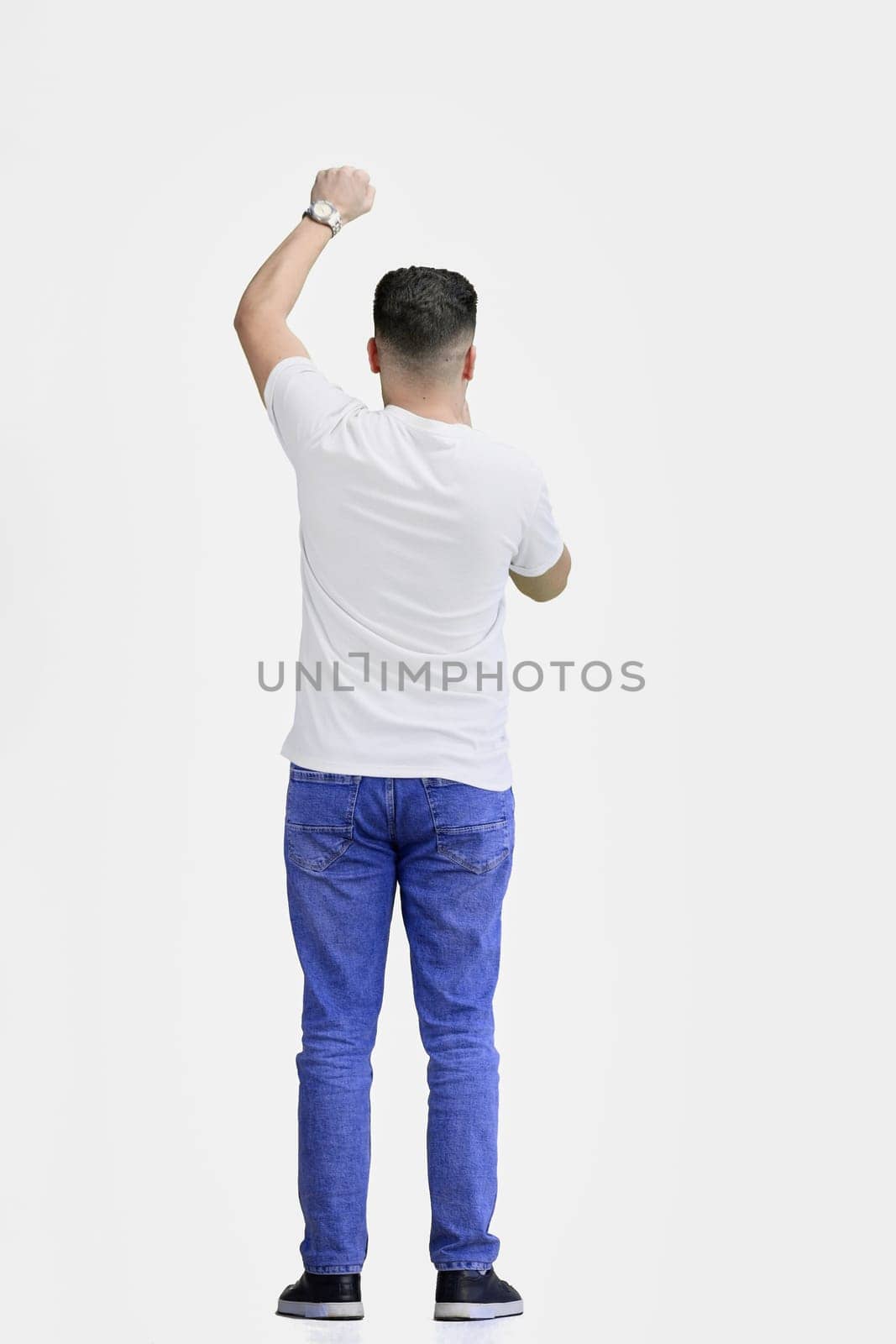 A man, full-length, on a white background, rejoices.