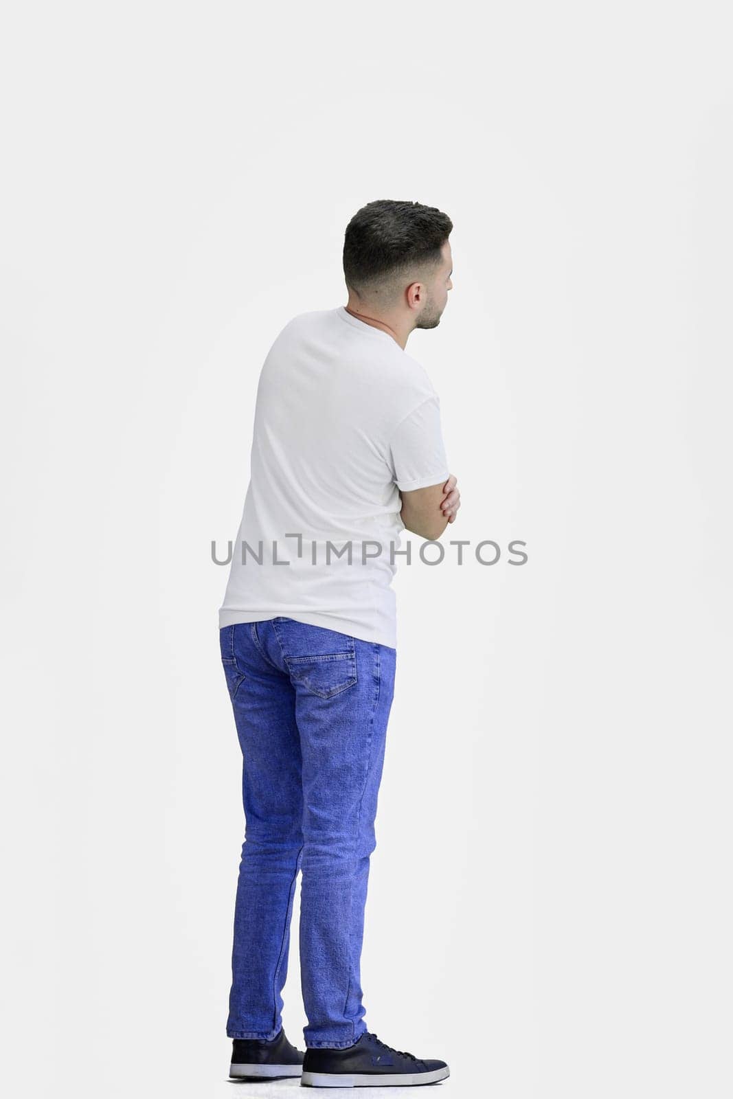 A man, full-length, on a white background, crossed his arms.
