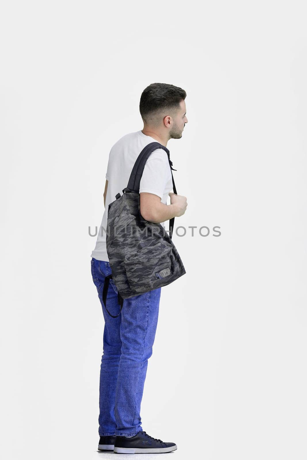 A man, full-length, on a white background, with a backpack.