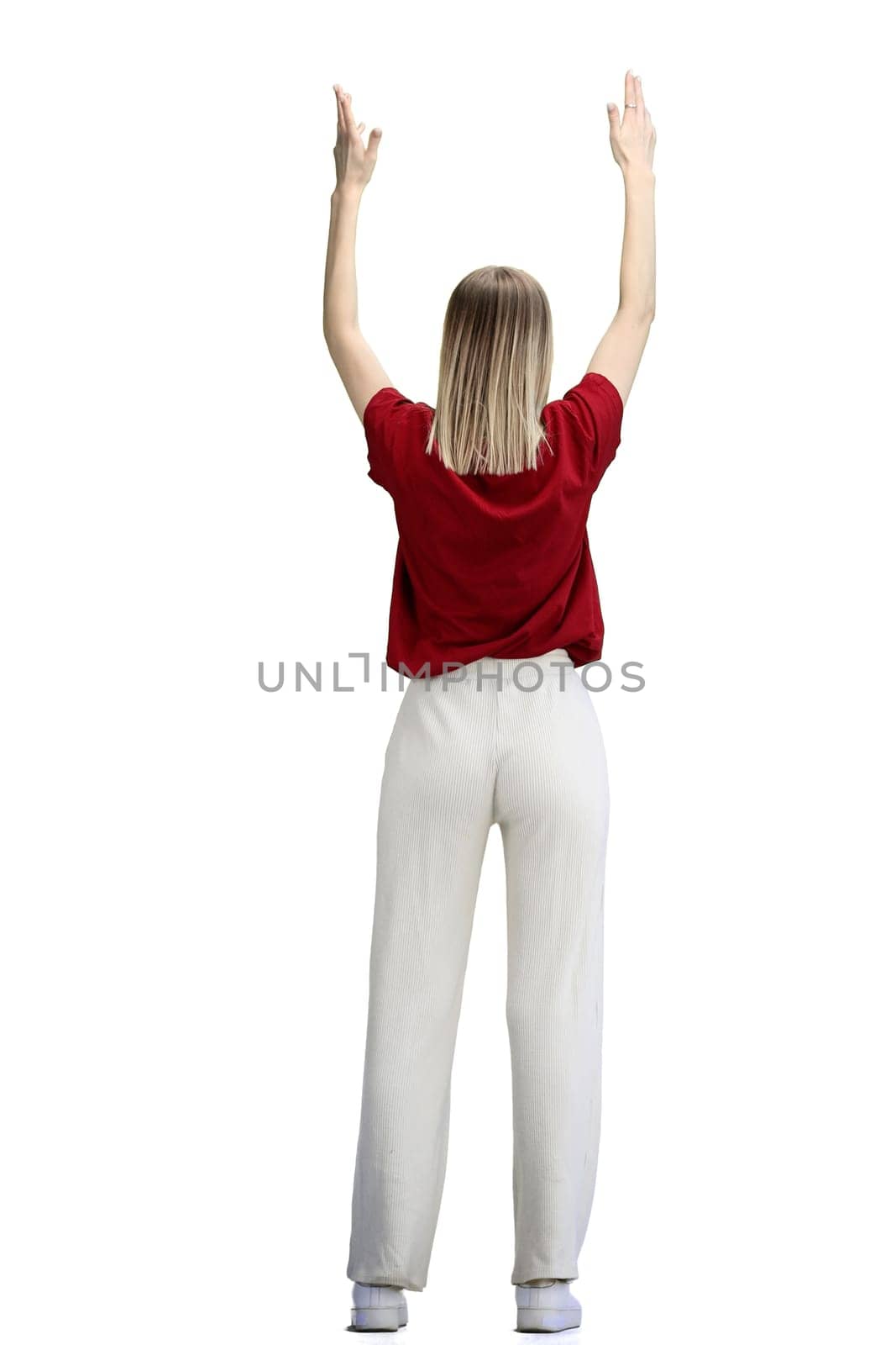 A woman, full-length, on a white background, raised her hands up.