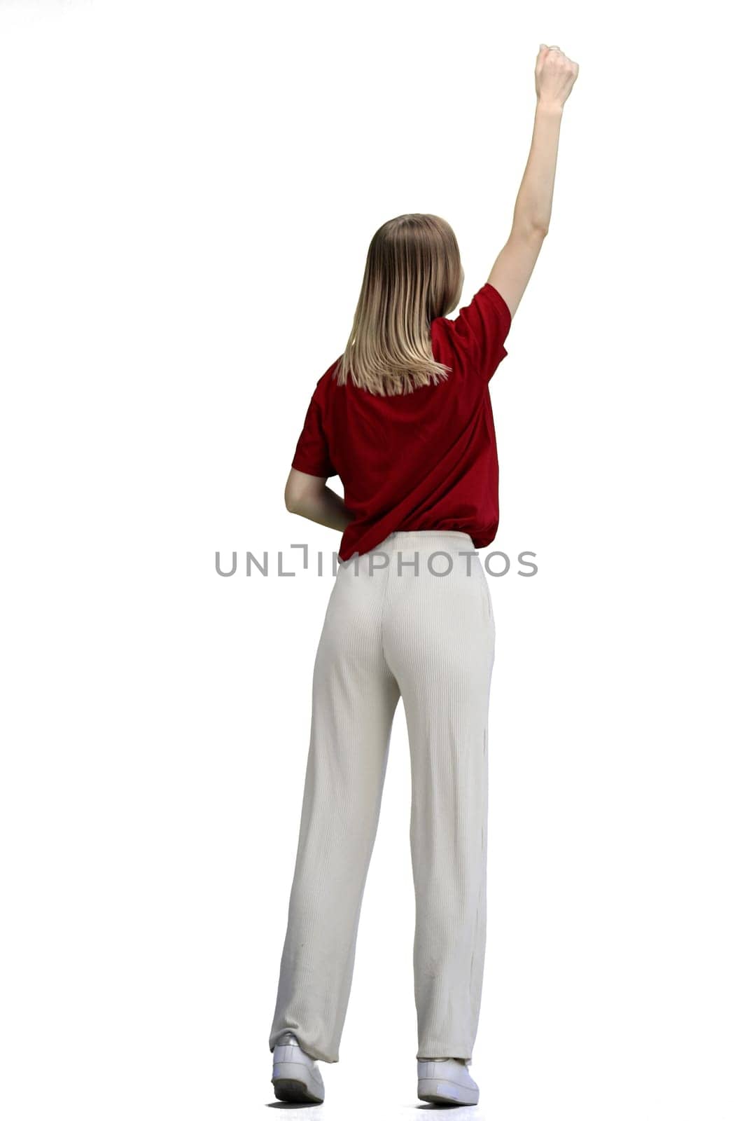 A woman, full-length, on a white background, raised her hand up.