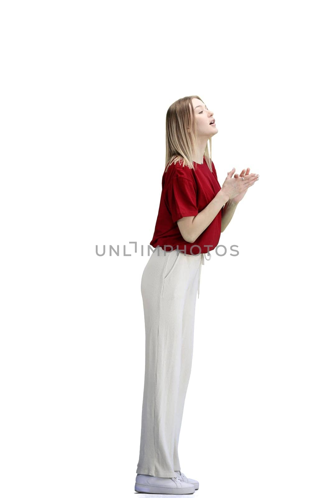 A woman, full-length, on a white background, folded her arms.