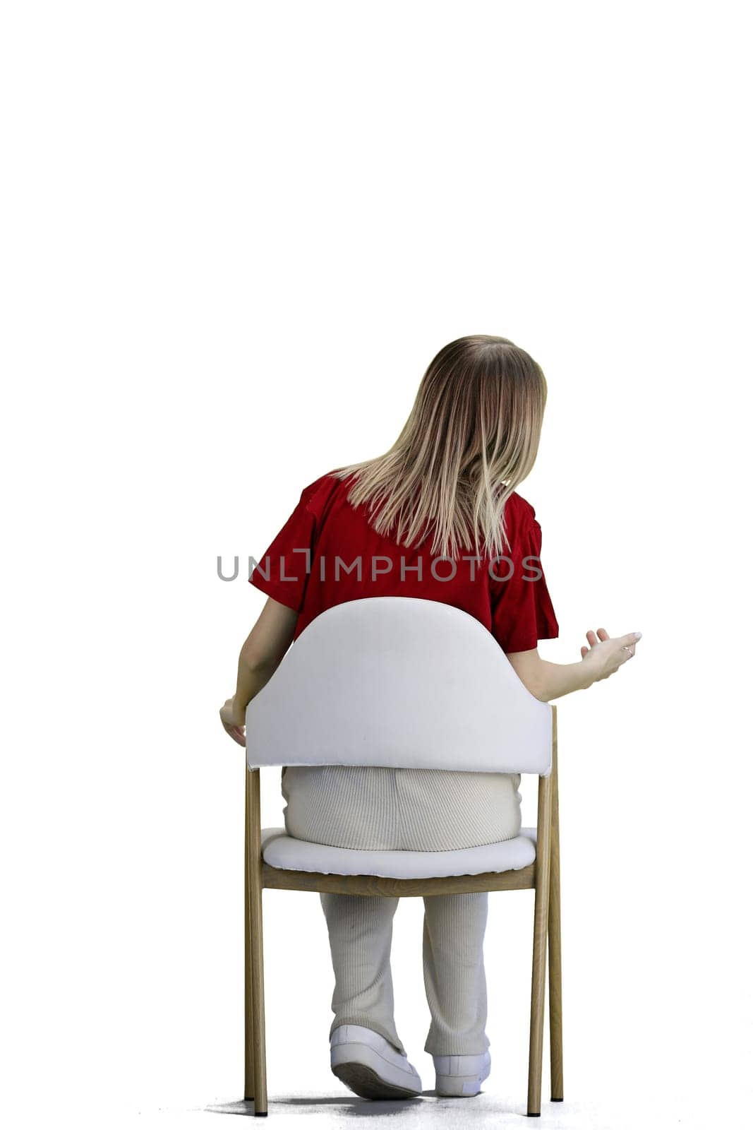 A woman, full-length, on a white background, sitting on a chair.
