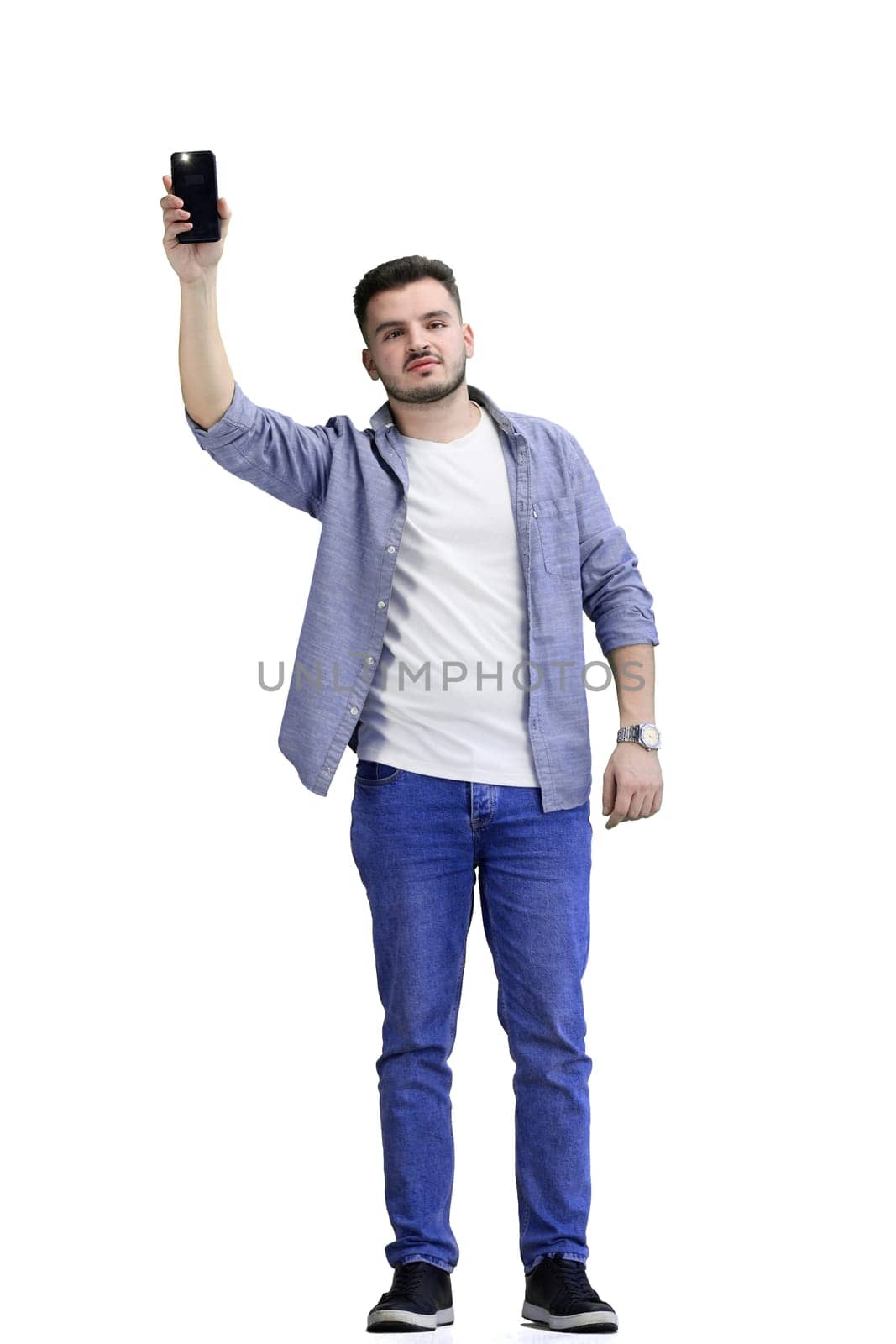A man, full-length, on a white background, waving his phone.