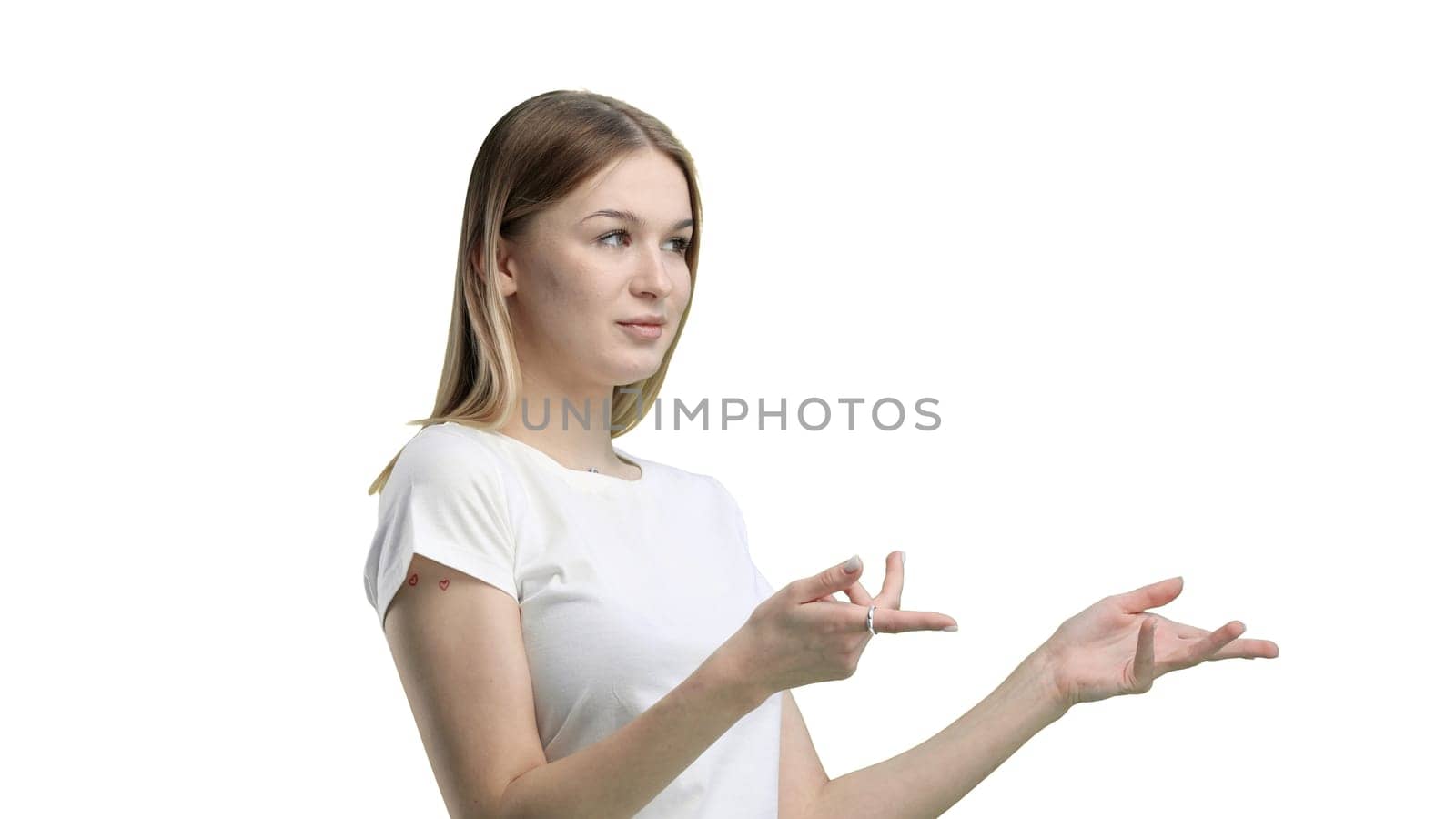 A woman, close-up, on a white background, points to the side.