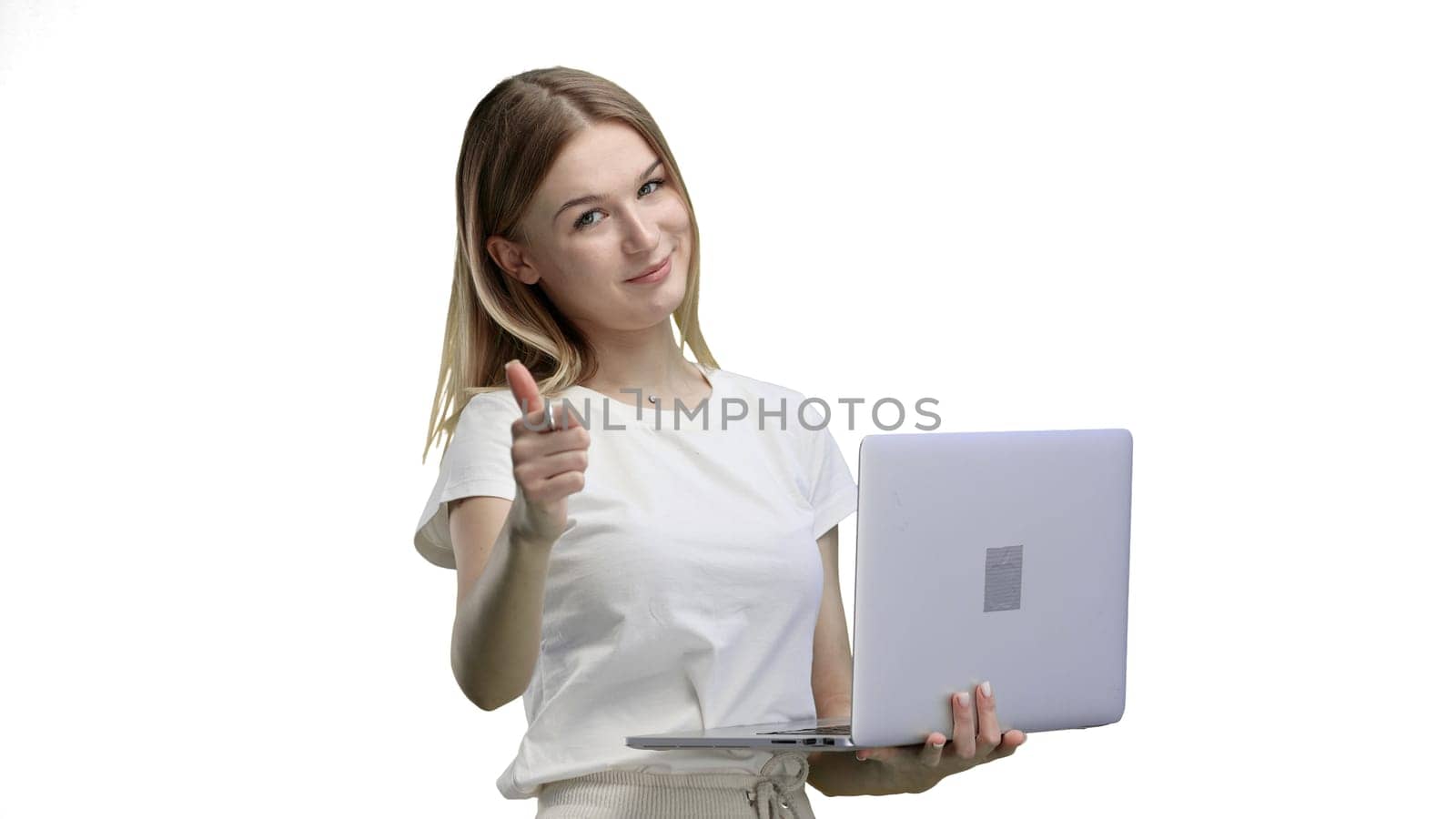 A woman, close-up, on a white background, uses a laptop.