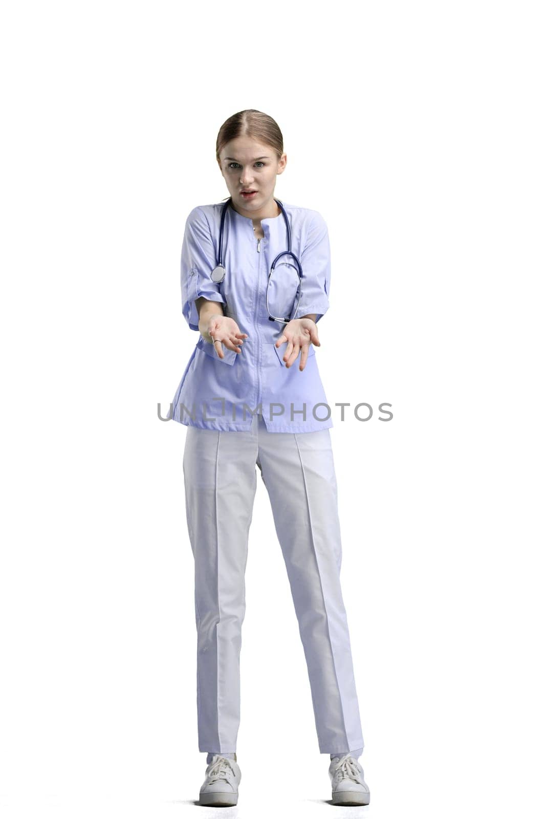 The doctor, in full height, on a white background, spreads her hands.