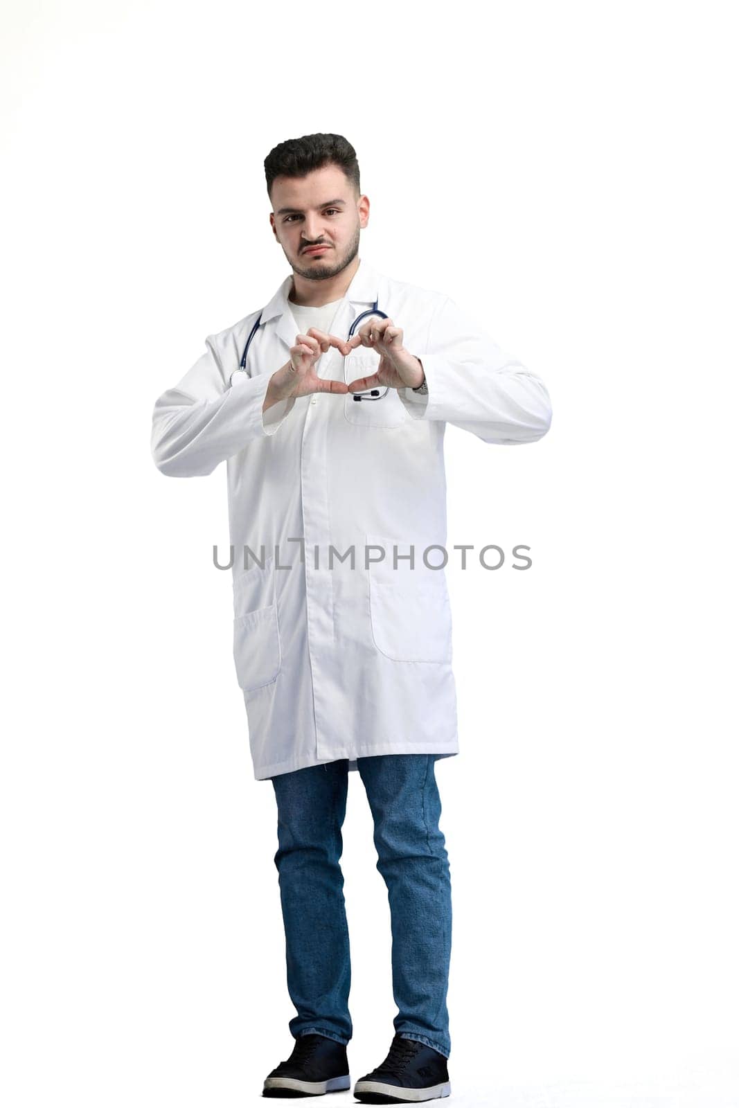Doctor, full-length, on a white background, showing a heart.