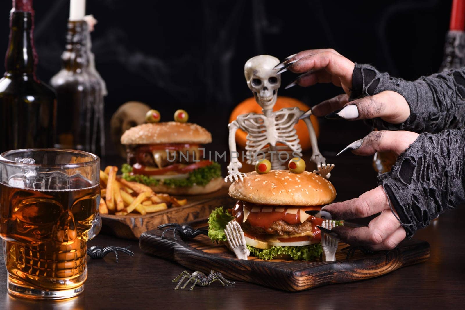 The witches hands want to grab the Monster Burger on the sitting skeleton. Perfect Halloween Party appetizer