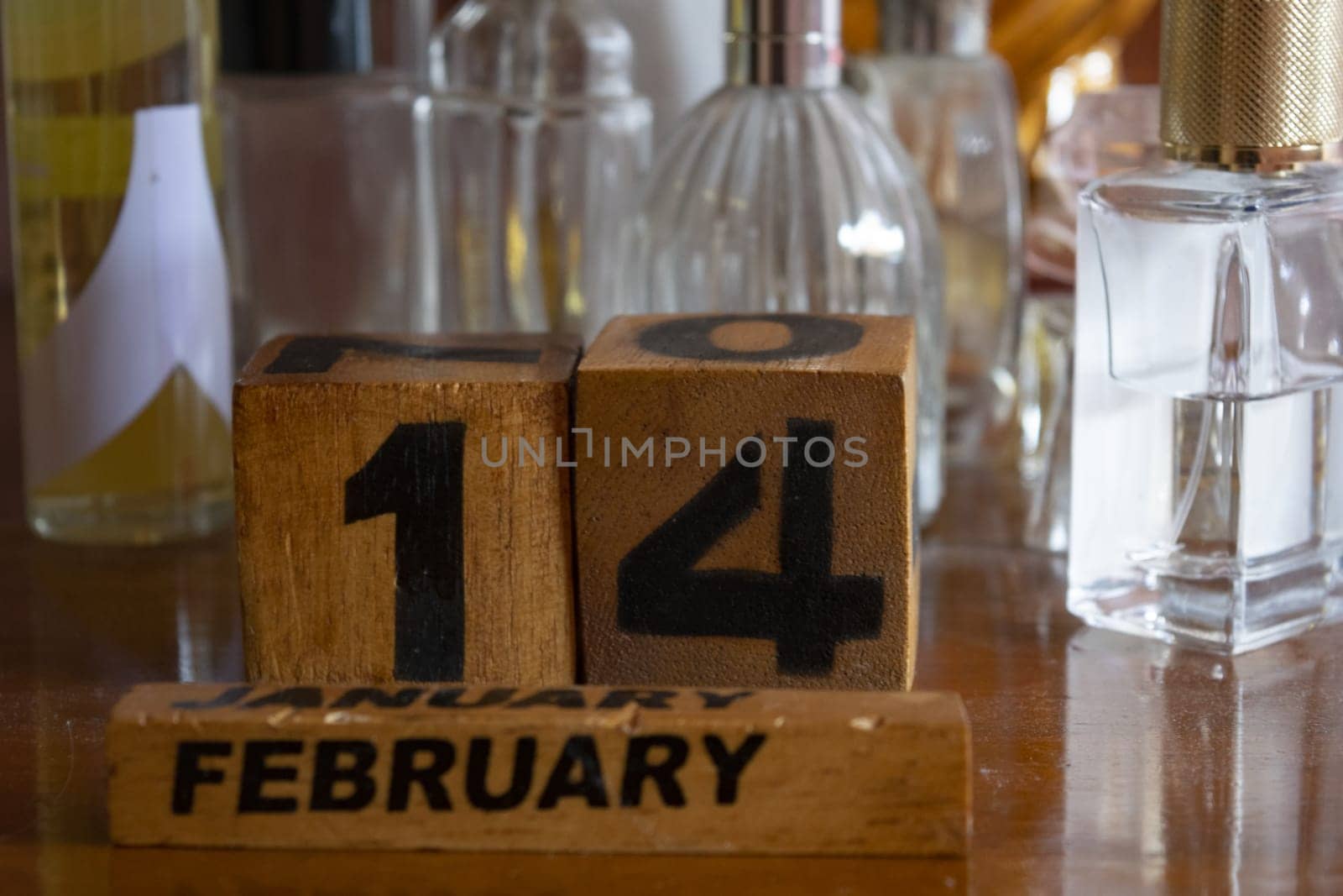 Valentine's Day represented through wooden cubes among perfume bottles