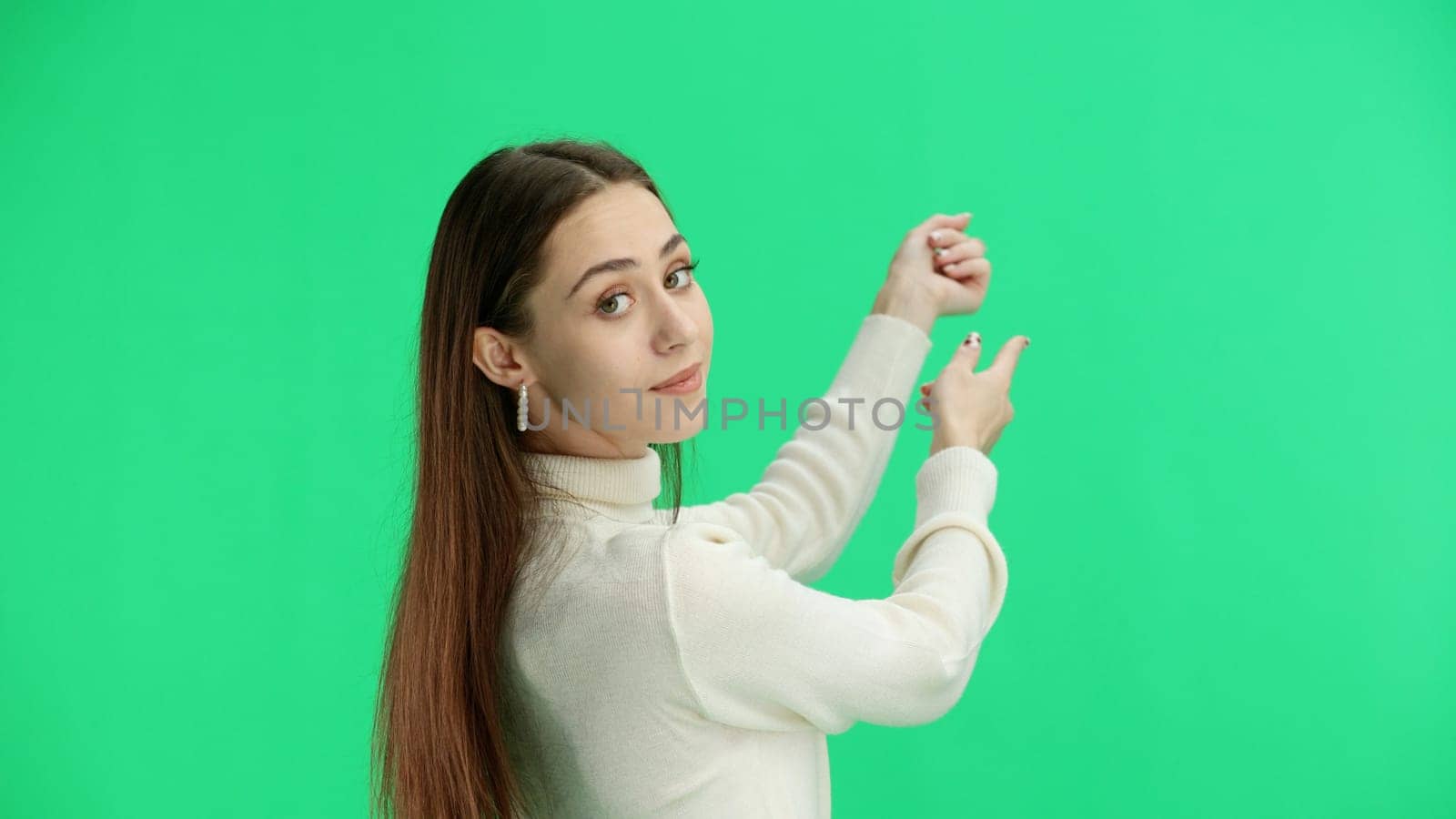 A woman, close-up, on a green background, points forward by Prosto