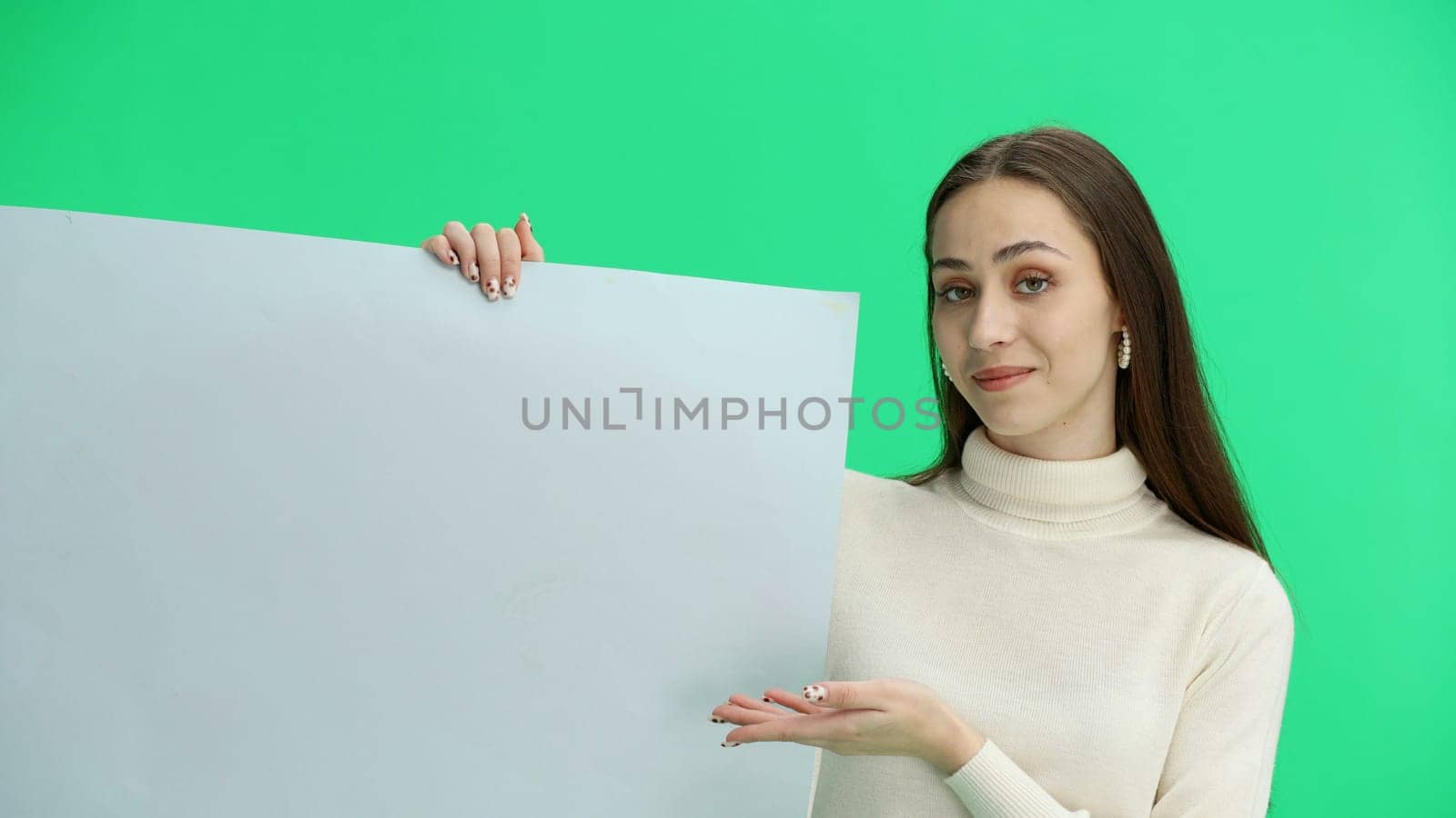 A woman, close-up, on a green background, shows a white sheet by Prosto