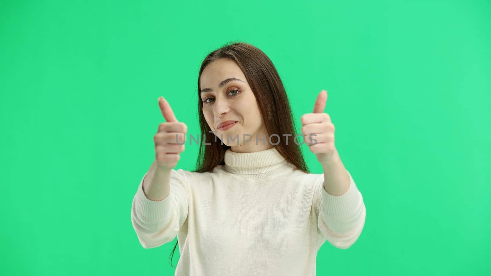 A woman, close-up, on a green background, shows her thumbs up by Prosto