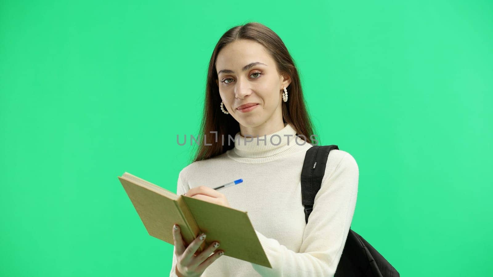 Woman, close-up, on a green background, with a backpack.