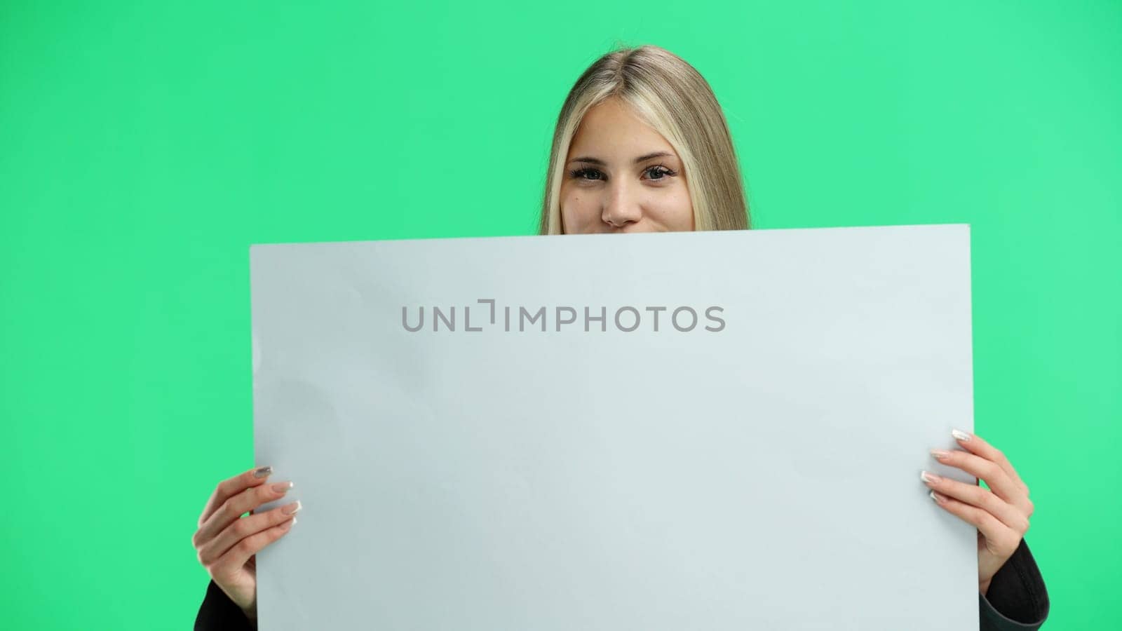 A woman, close-up, on a green background, shows a white sheet.