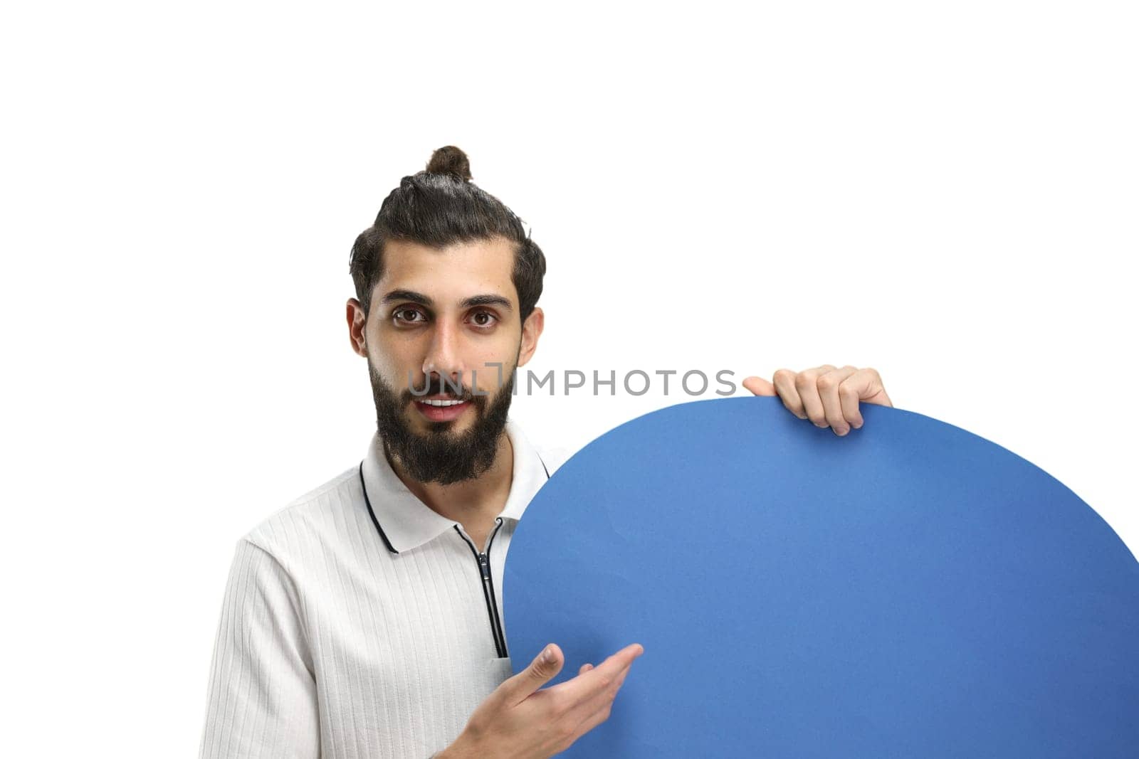 A man, close-up, on a white background, shows a blue comment sign by Prosto
