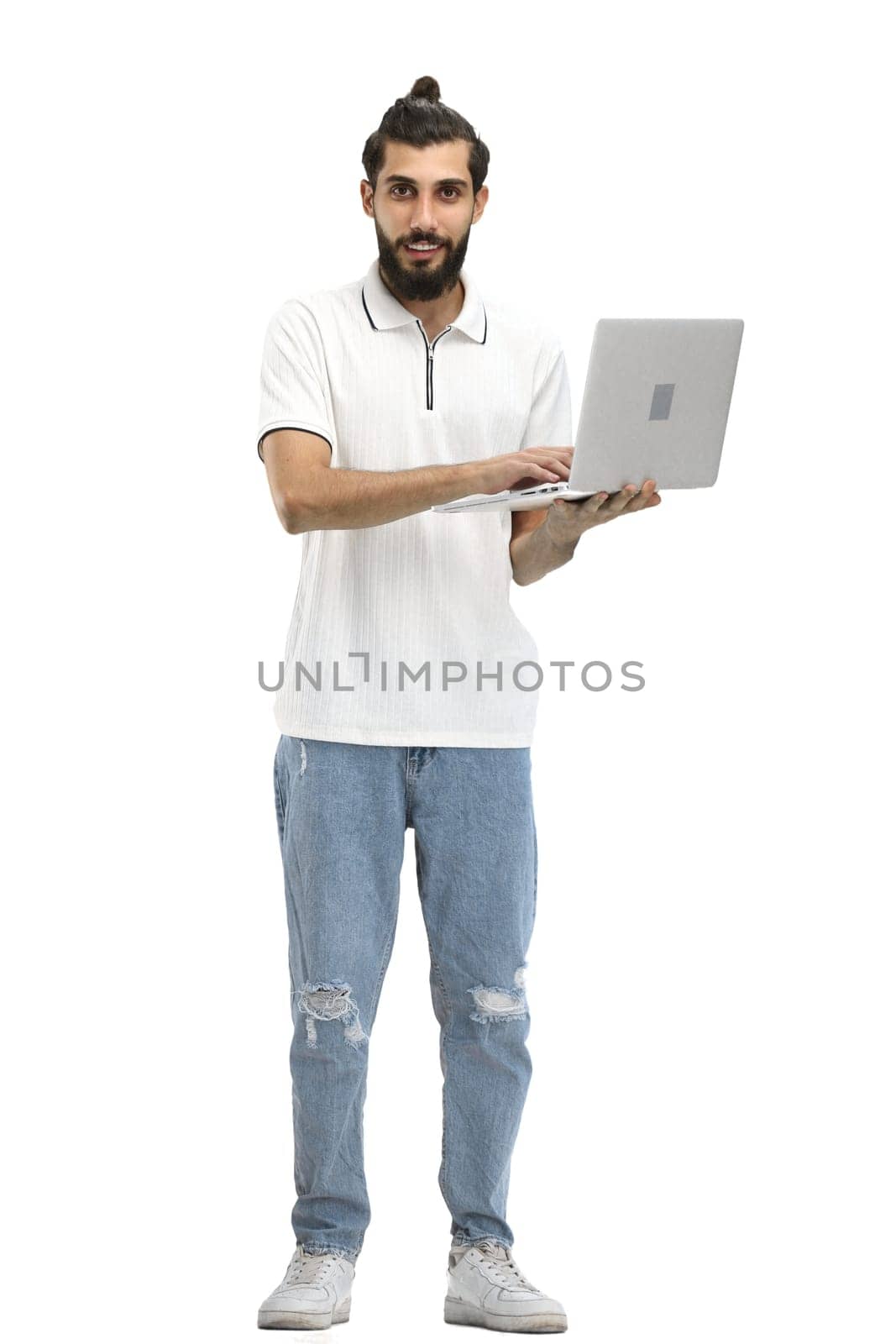 A man, full-length, on a white background, with a laptop.