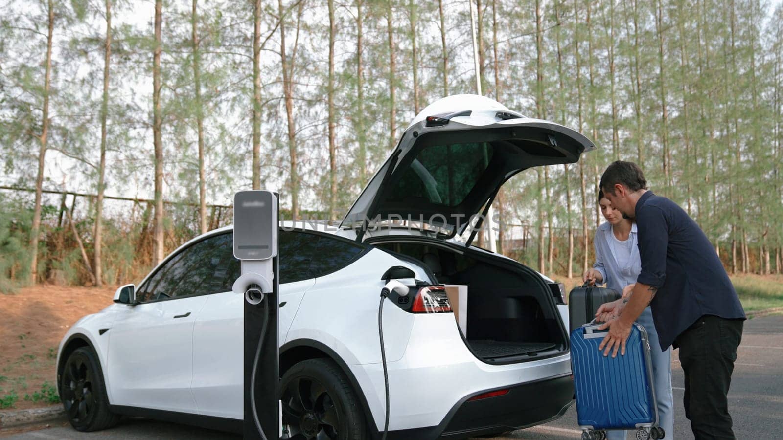 Couple recharge their EV car with electric battery charging station. Exalt by biancoblue