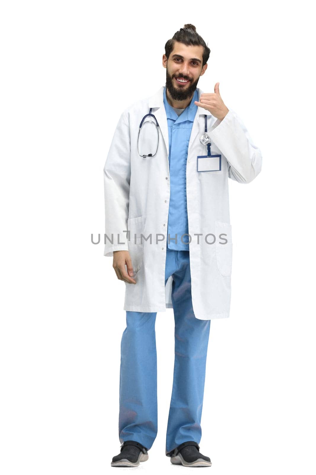 A male doctor, full-length, on a white background, shows a call sign by Prosto