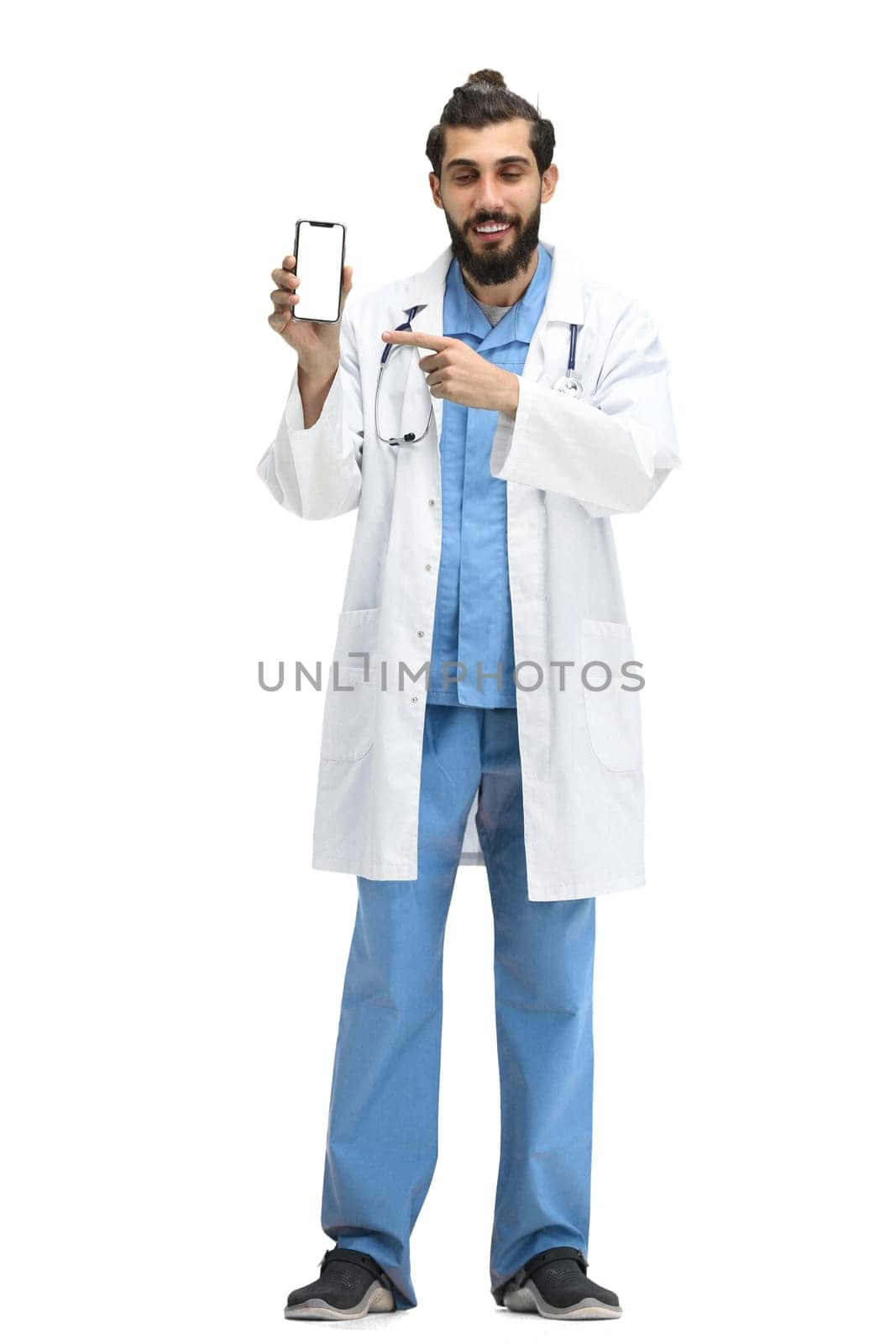 Male doctor, full-length, on a white background, with a phone.