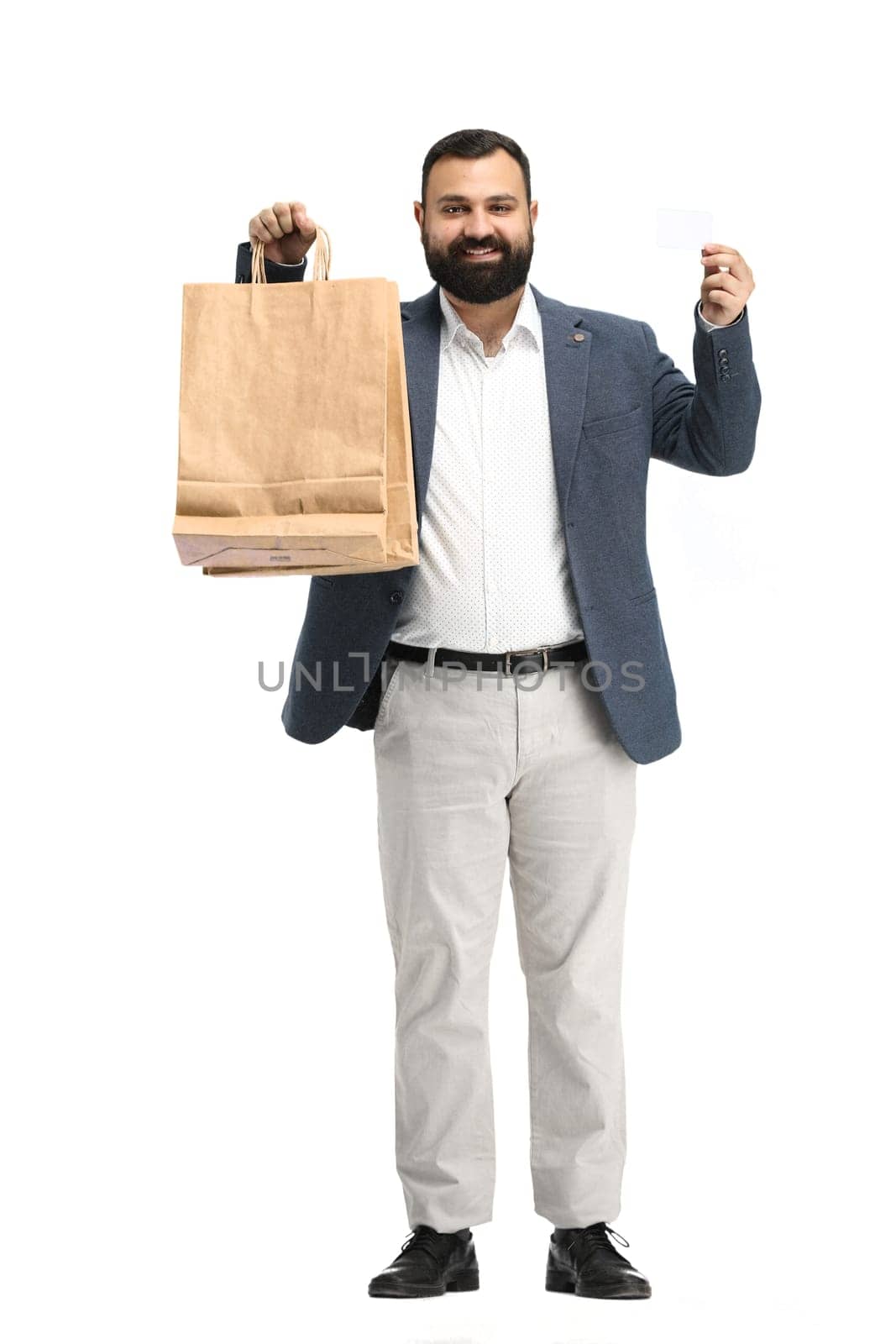 A man, full-length, on a white background, with packages and a card.