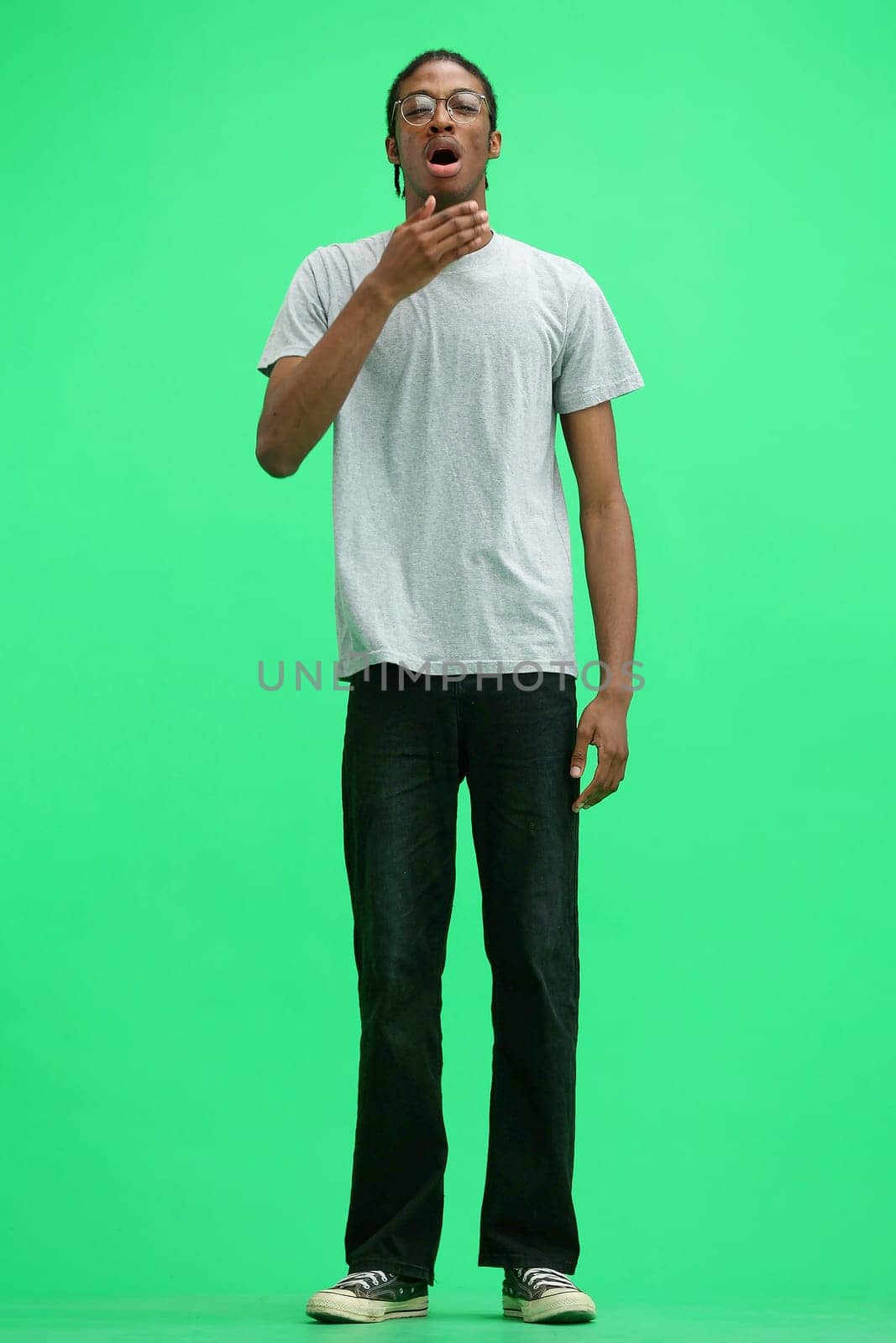 A man in a gray T-shirt, on a green background, full-length, w by Prosto